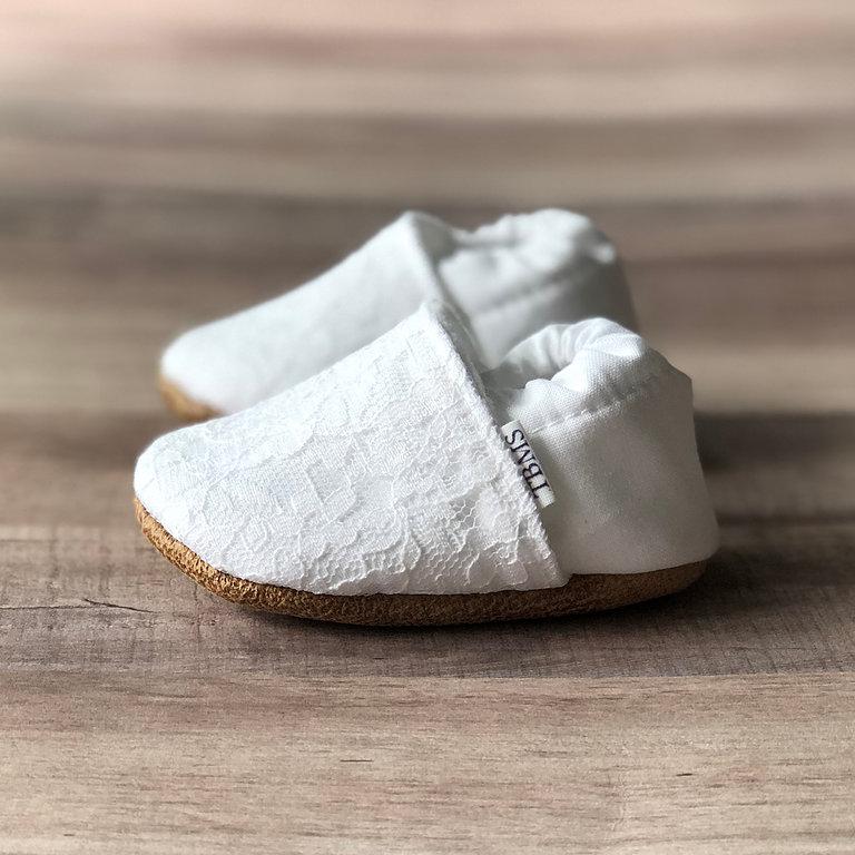 Side view Lacey White Cotton Canvas Moccasins on a soft ash hued wood table
