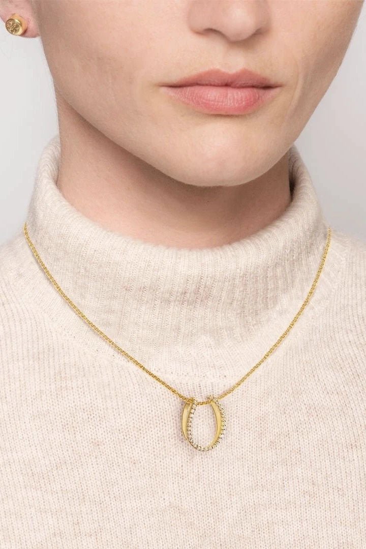 Levade Horseshoe Necklace in Gold Vermeil on a female model wearing an ivory knit turtleneck