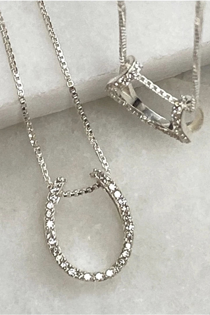 Two Levade Horseshoe Necklace in Silver , one laying and one hanging showing the pendants - L'Atelier Global