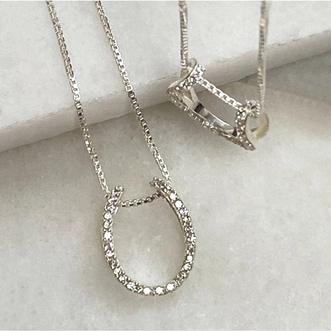 Two Levade Horseshoe Necklace in Silver , one laying and one hanging showing the pendants - L'Atelier Global