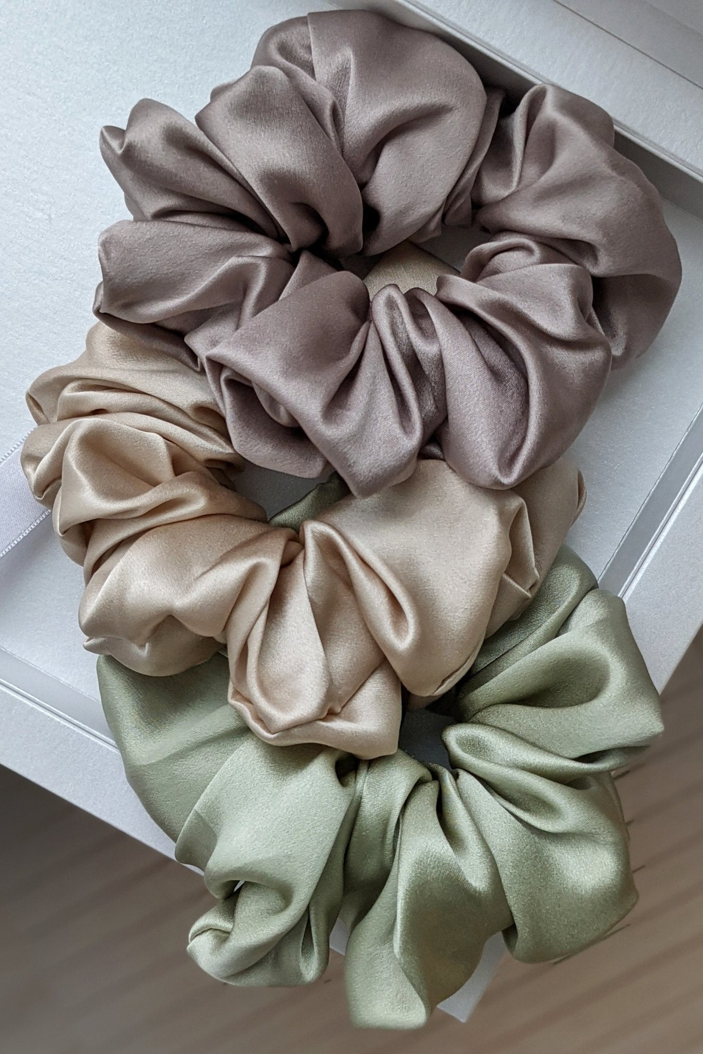 Luxe Mulberry Silk Jumbo Scrunchie all colors laying on a wooden table
