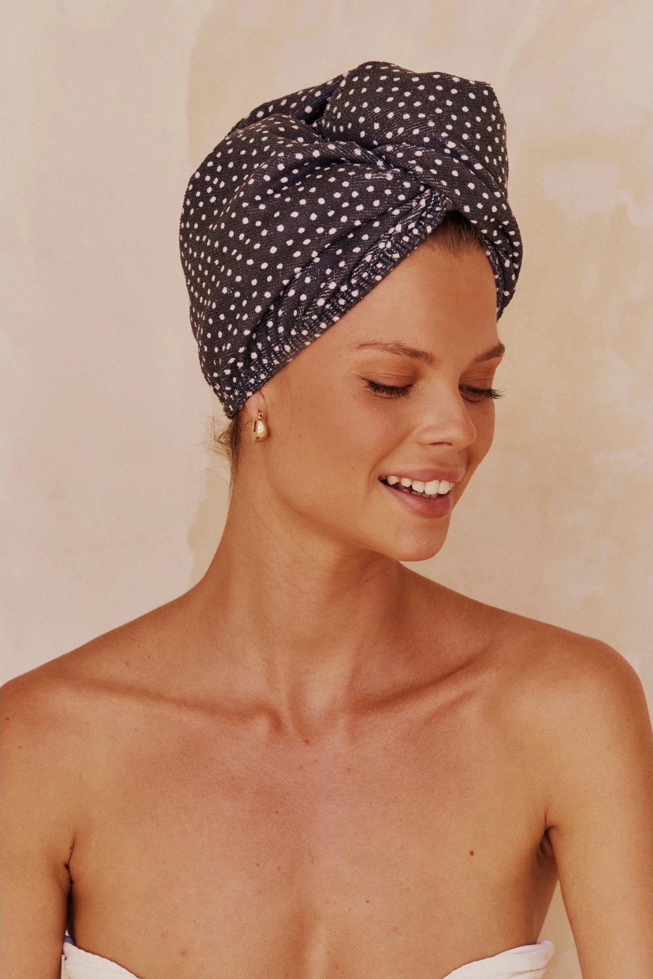 Side view of Microfiber Hair Towel in French Navy Polka Dot wrapped around a woman's head