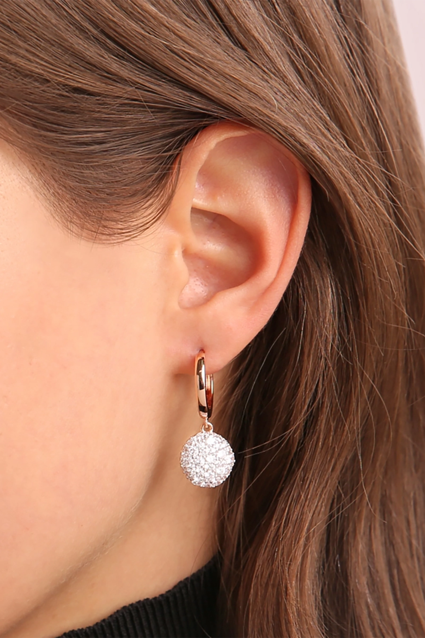 Milano Circle Golden Rosé Earrings with Pavé Pendant in Cubic Zirconia on a model's left ear.