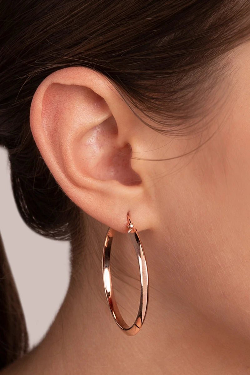 Milano Hanging Golden Rosé Hoop Earrings on a models right ear