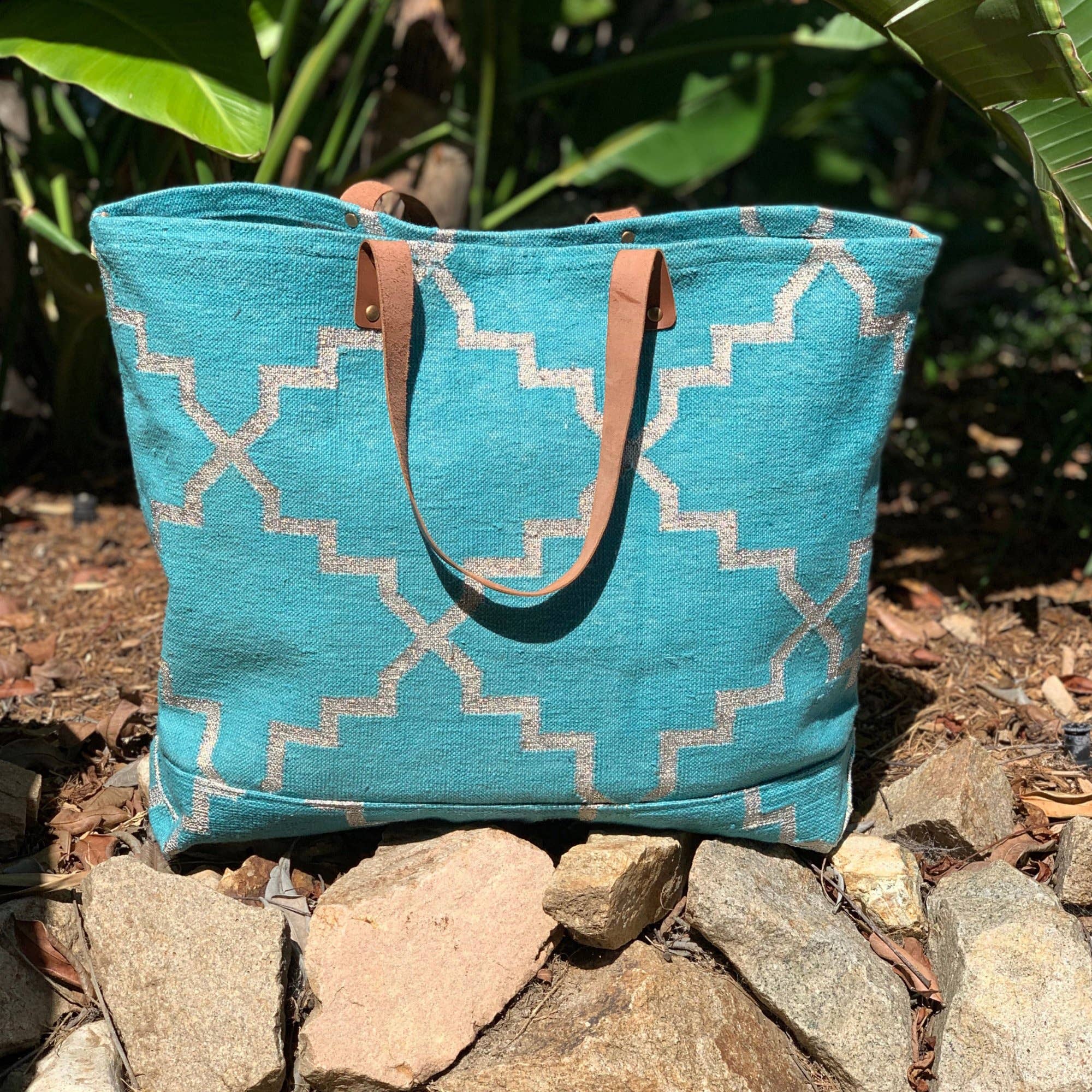 Napa Get Away Tote in Turquoise sitting on a stone pebbled surface