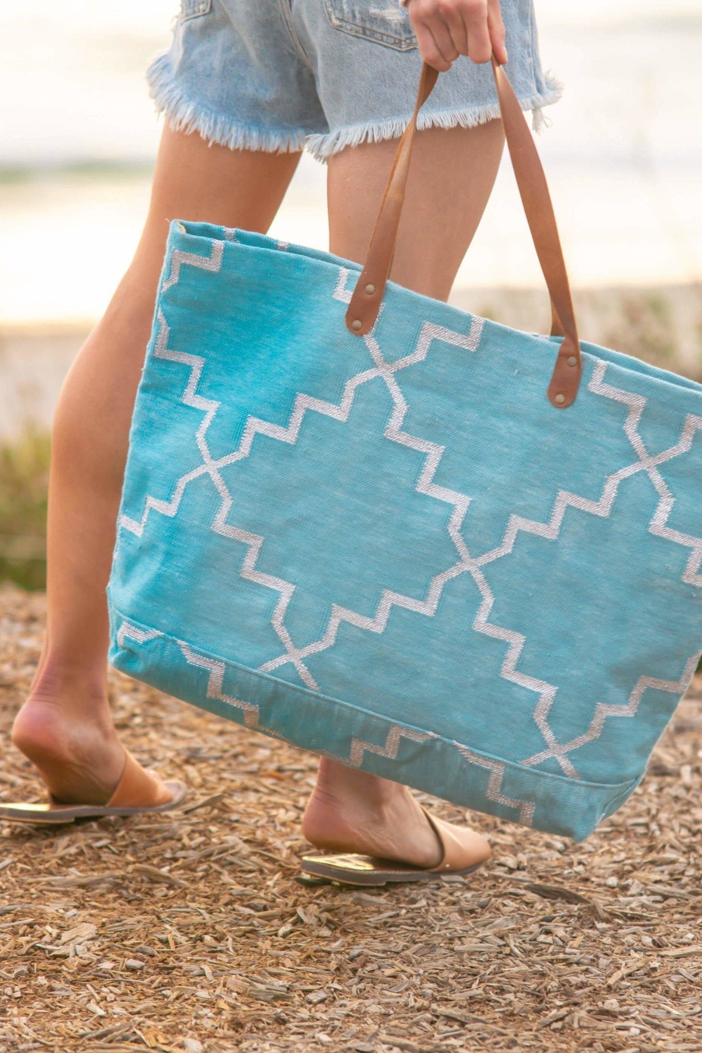 Napa Get Away Tote in Turquoise held by a woman on the beach