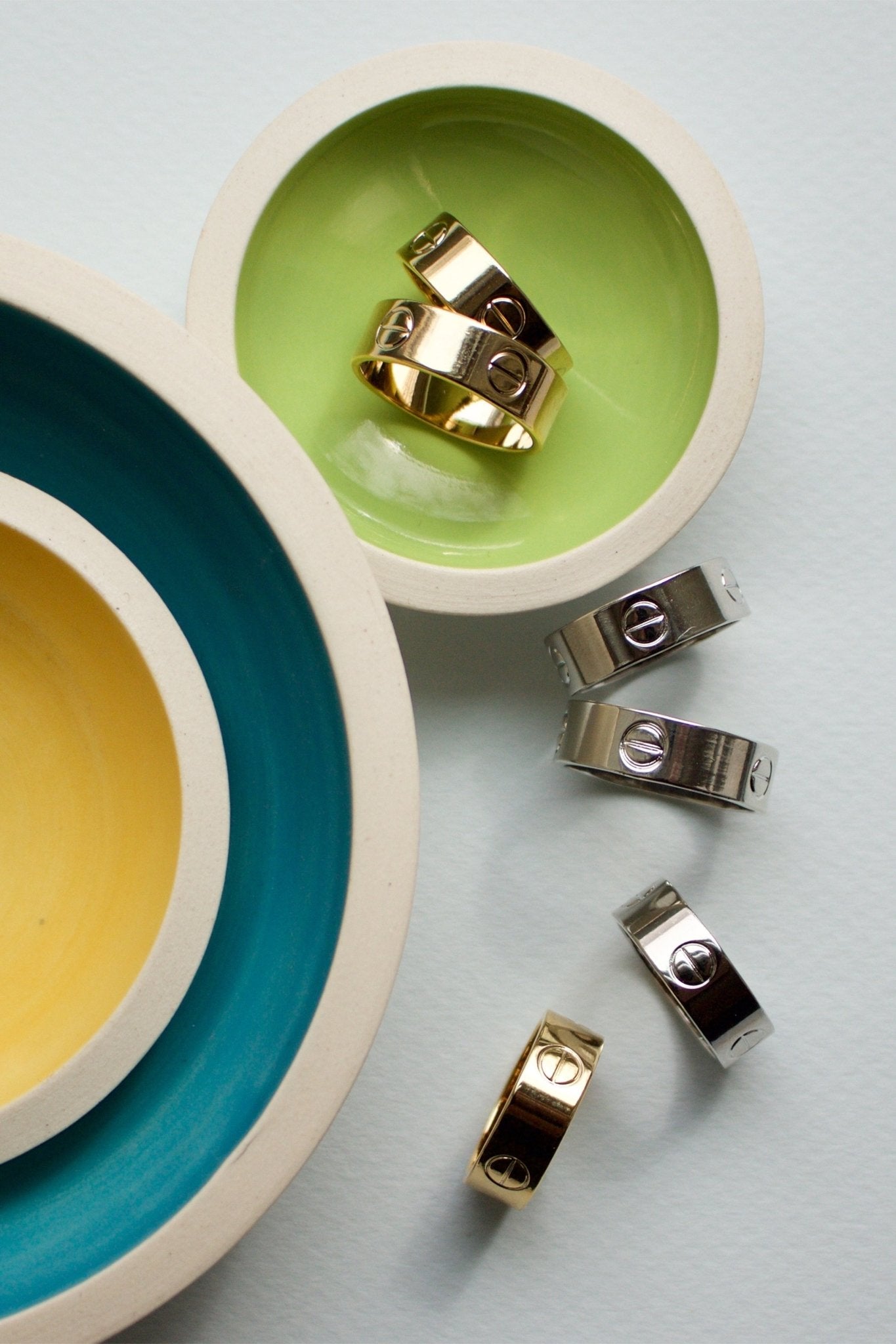 NYC Nailhead Rings on colorful deco background using yellow, dark turquoise and lime green colored dishes - L'Atelier Global