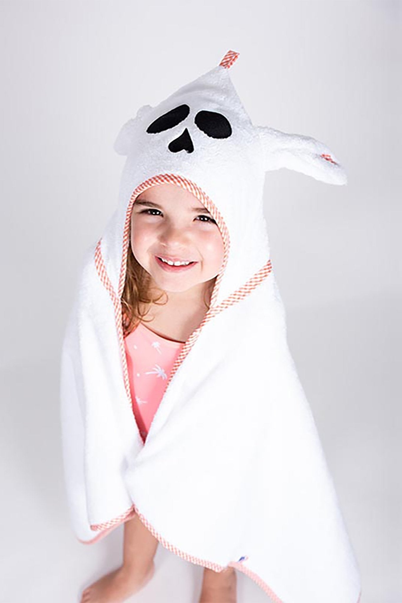 A young girl wearing the unisex French Organic Cotton Bath Cape - L'Atelier Global