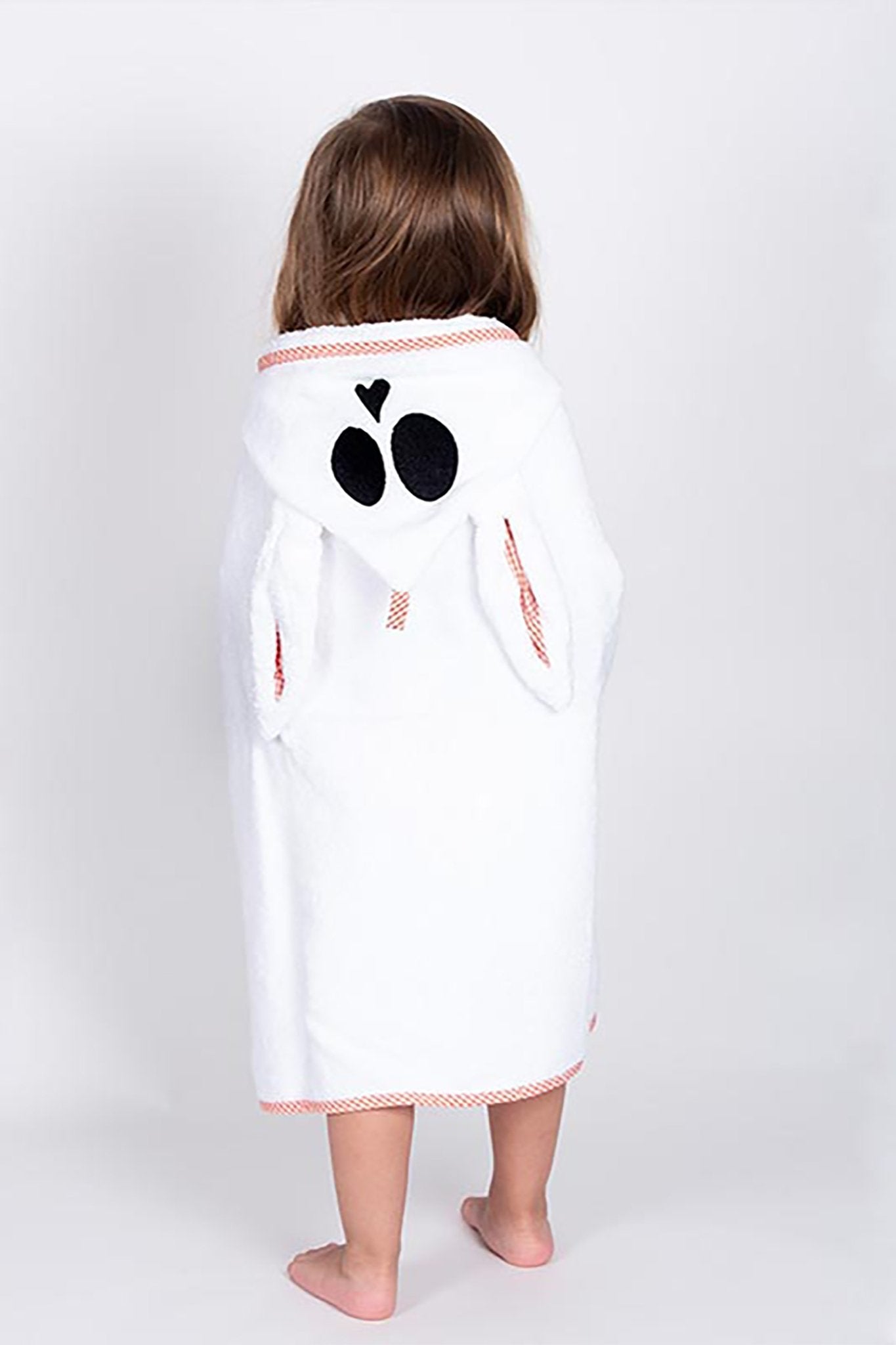 The back of a young girl wearing the unisex French Organic Cotton Bath Cape - L'Atelier Global