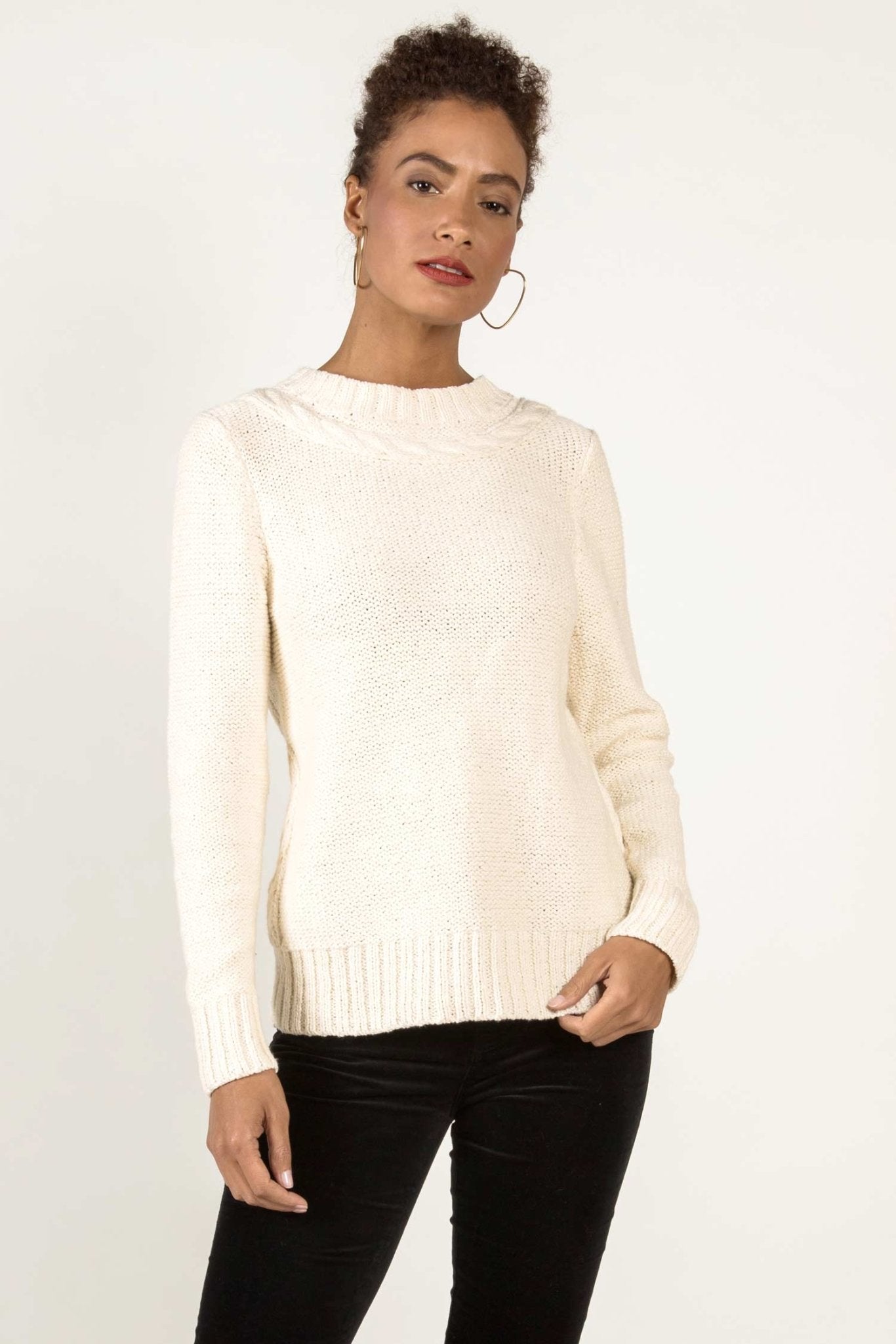 Pima Cotton Luxe Cable Sweater in white on model wearing black pants and standing with white background - L'Atelier Global