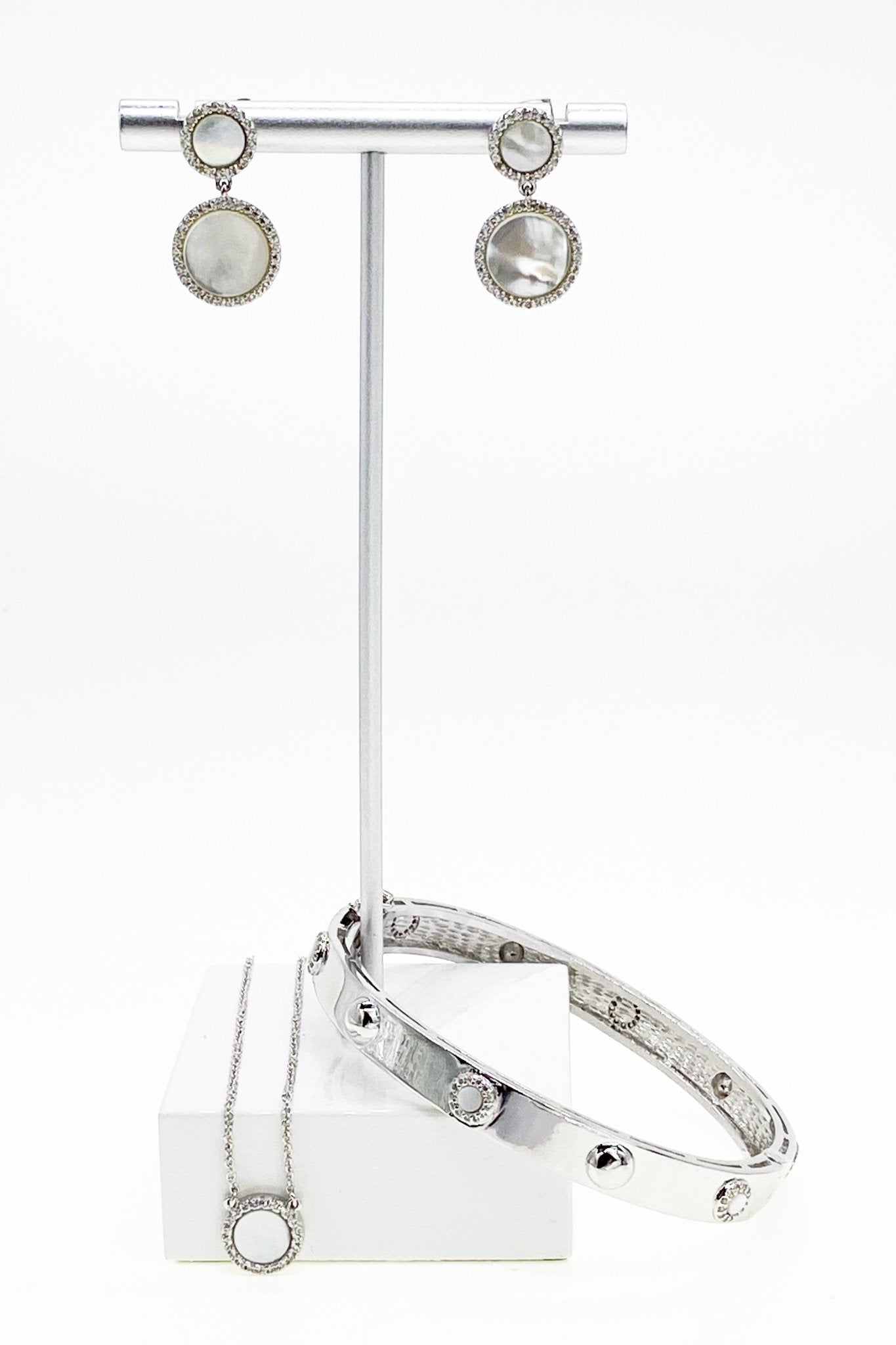 Platinum Dazzle Mother of Pearl Bangle and matching earrings on jewelry stand