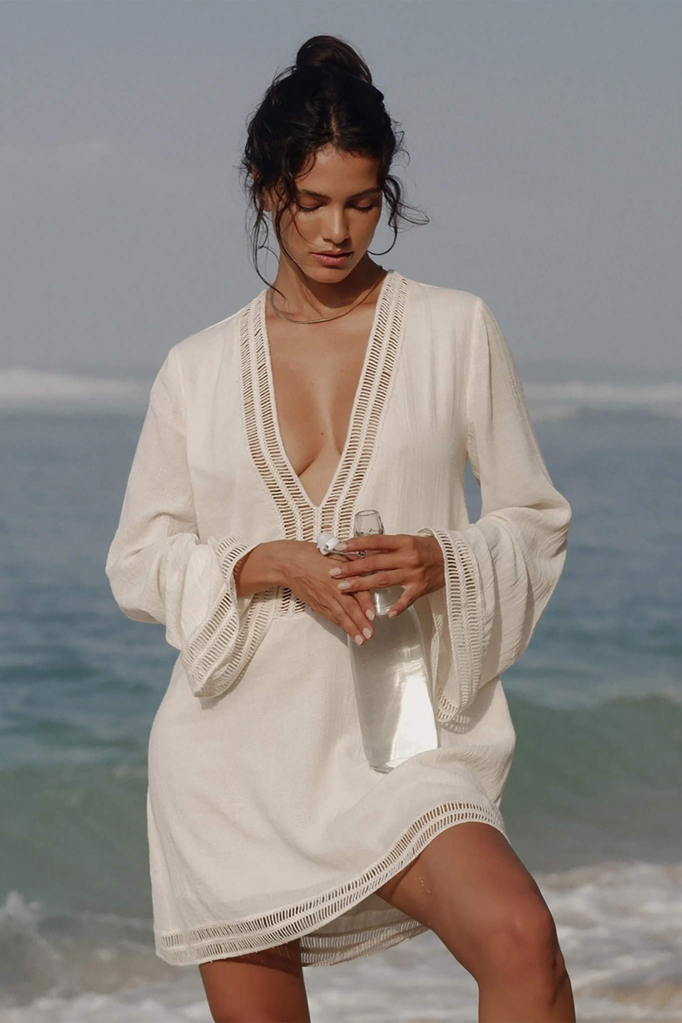 Positano Turkish Cotton Cover Up Dress with Lace in Natural on a model standing on the beach in front of the ocean