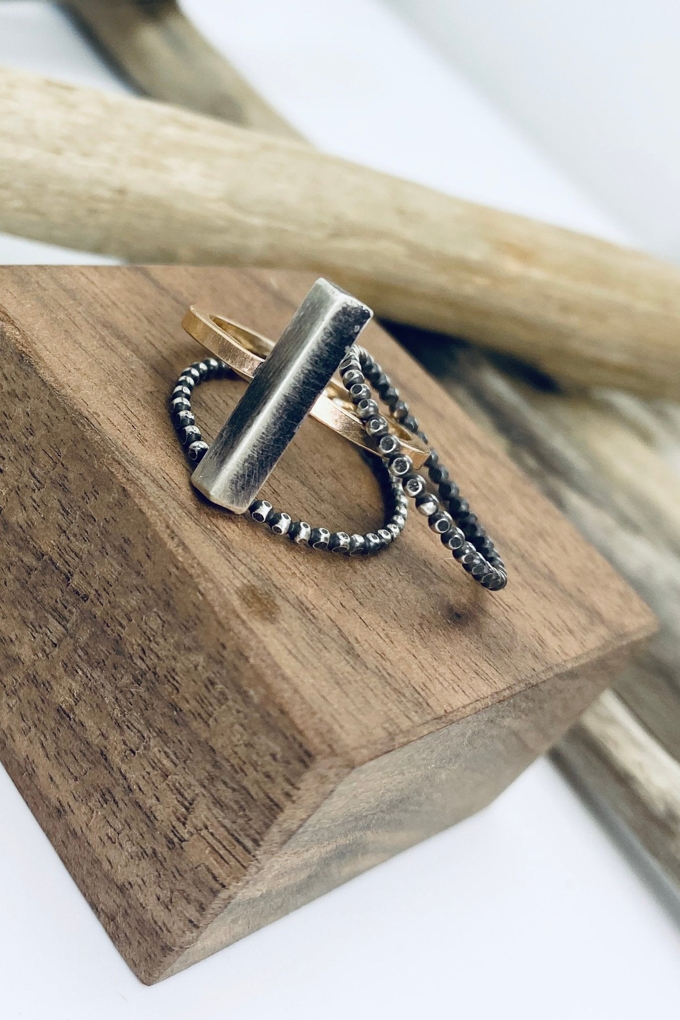 Pyramid Stacking Rings laying on a piece of textured wood - L'Atelier Global
