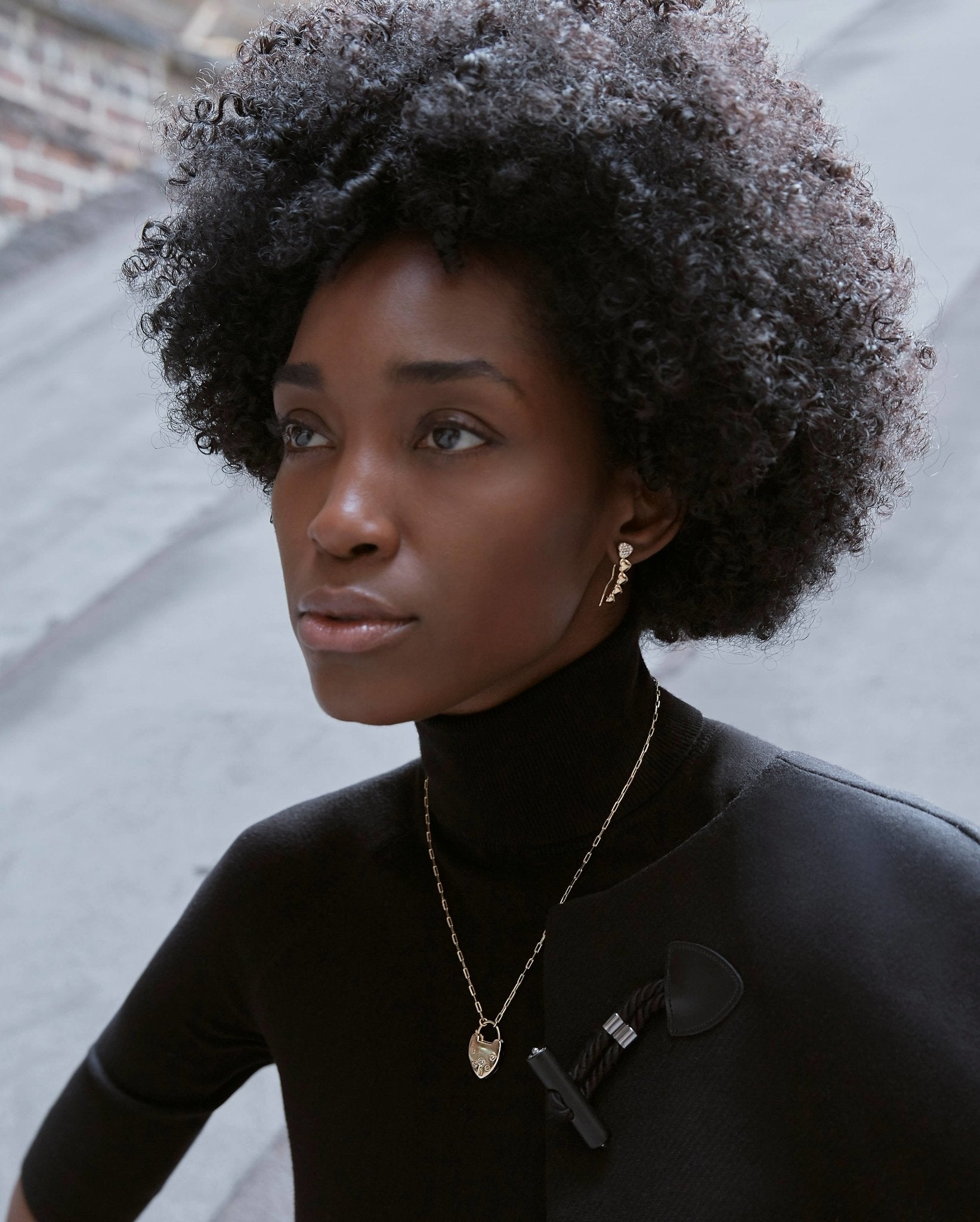 Rio Gold Lock Heart Necklace on a model wearing a black turtleneck - L'Atelier Global