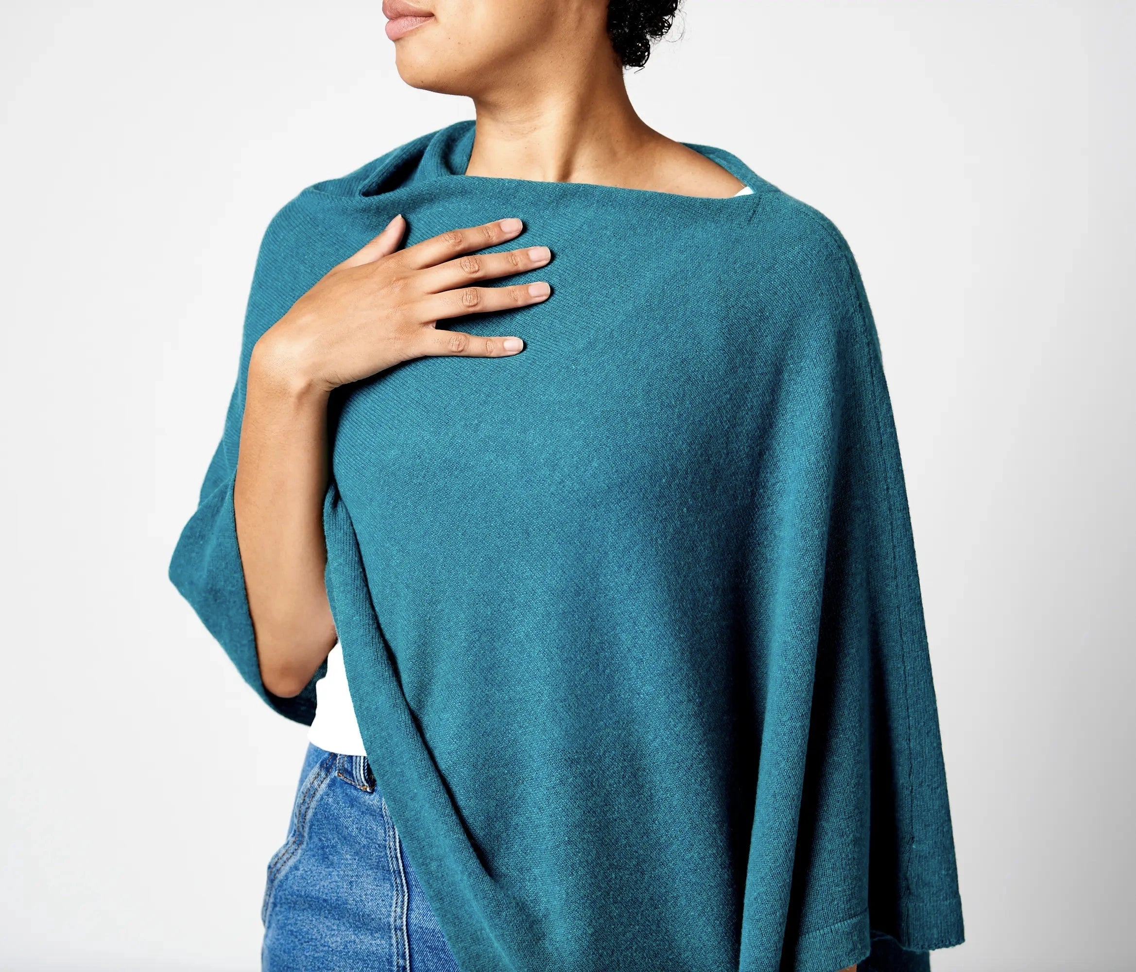 Roma Cashmere Blend Asymmetrical Poncho in teal on model wearing a white top and blue jeans - L'Atelier Global