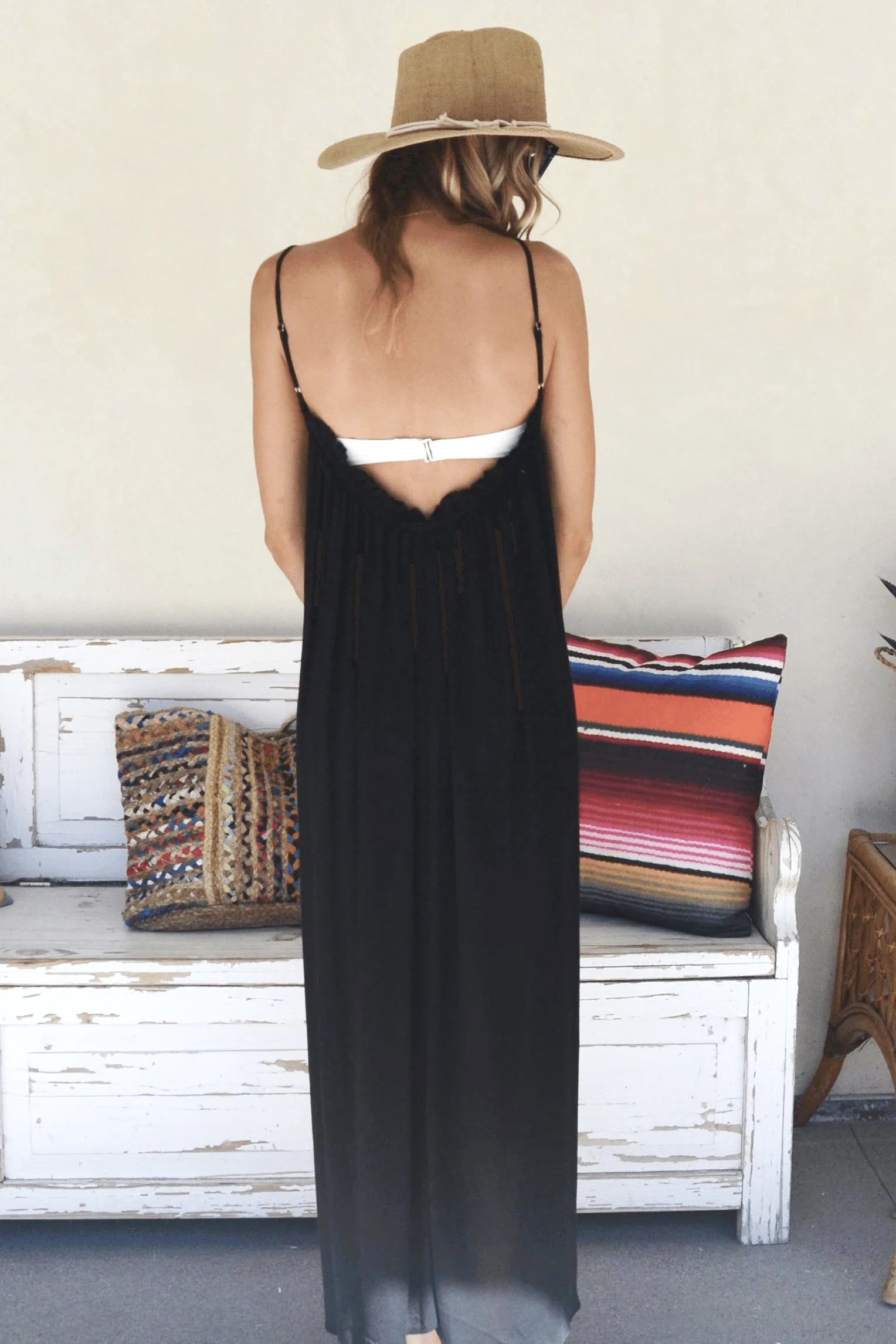 Woman in a straw hat showing the back of the Sea Side Maxi Cover Up in Black