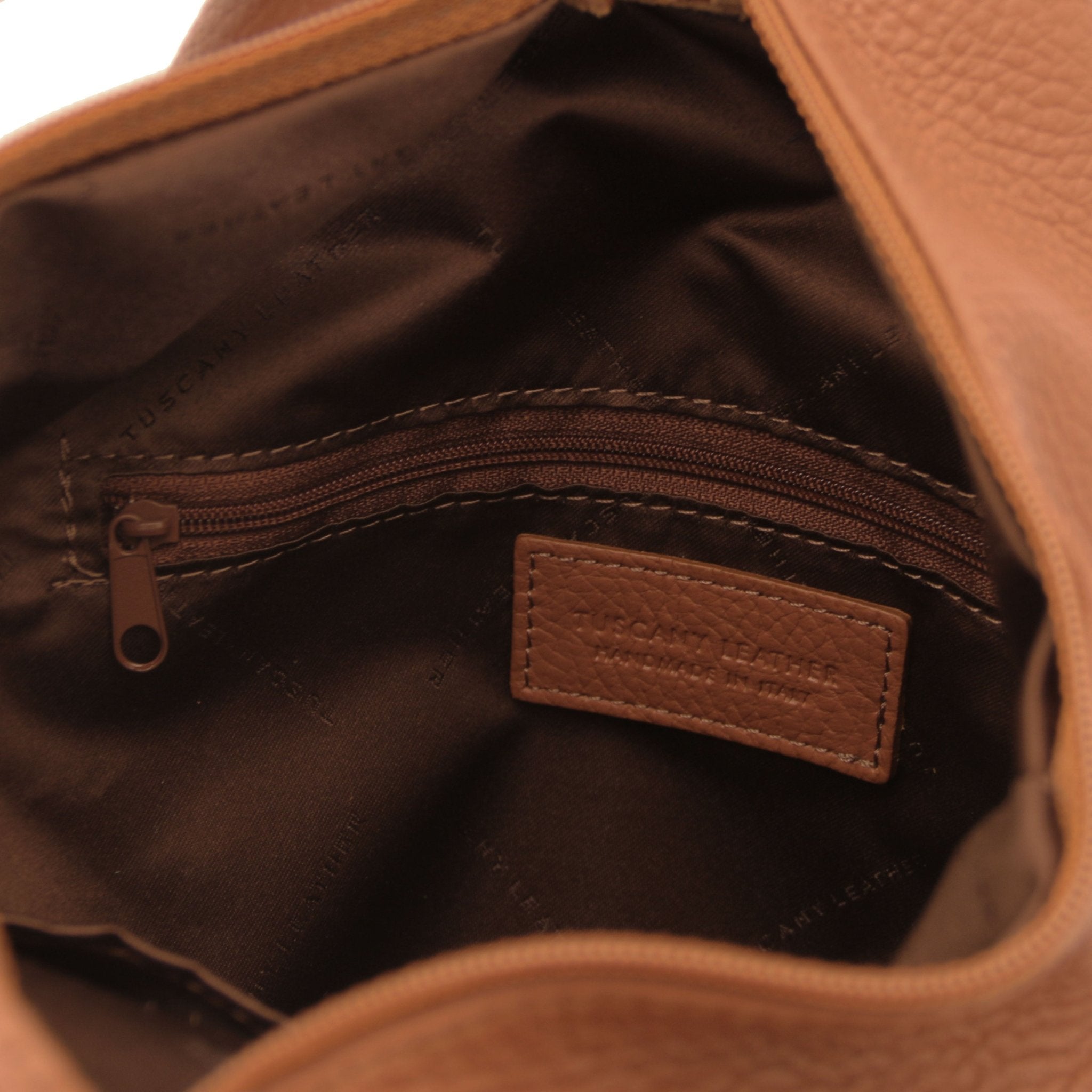 Interior zip pocket view Shanghai Leather Backpack in cognac showing brown lining
