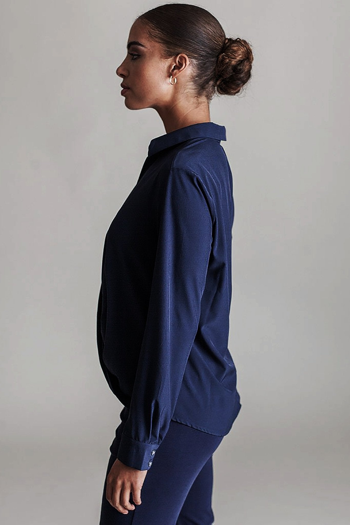 Side view of a female model wearing the Signature Barcelona Blouse in Black - L'Atelier Global