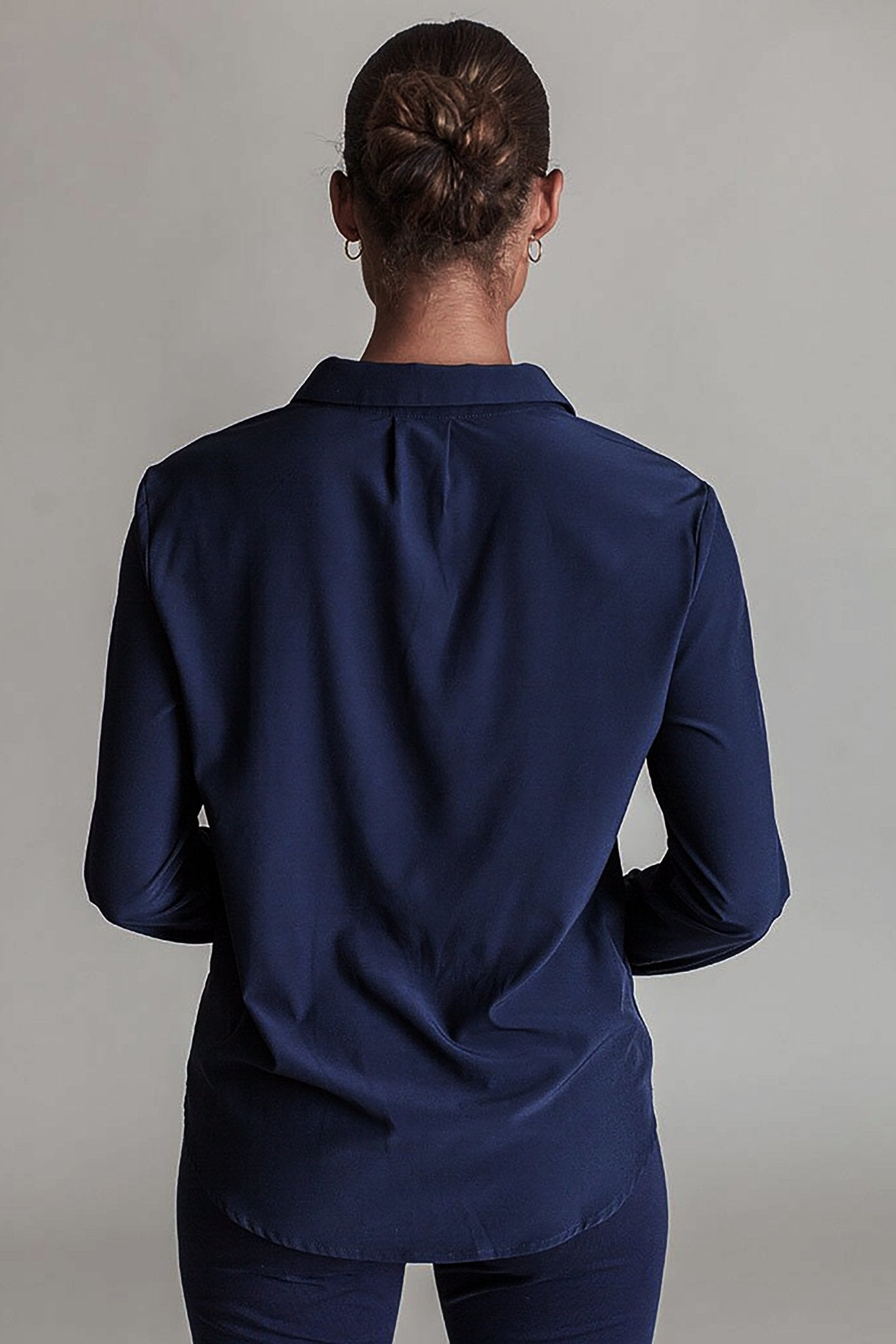 Side view of a model wearing the Signature Barcelona Blouse in Navy - L'Atelier Global