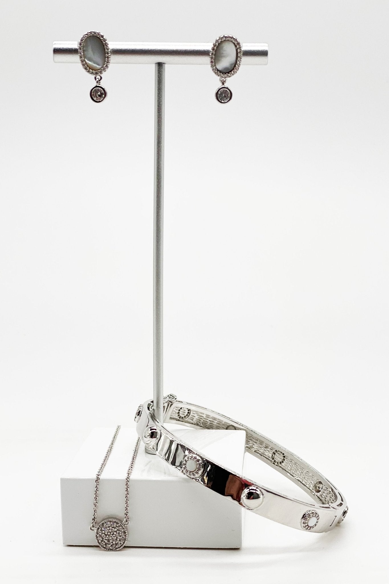 Signature Platinum Pave Necklace and matching bracelet on a silver jewelry stand with white marble base - L'Atelier Global