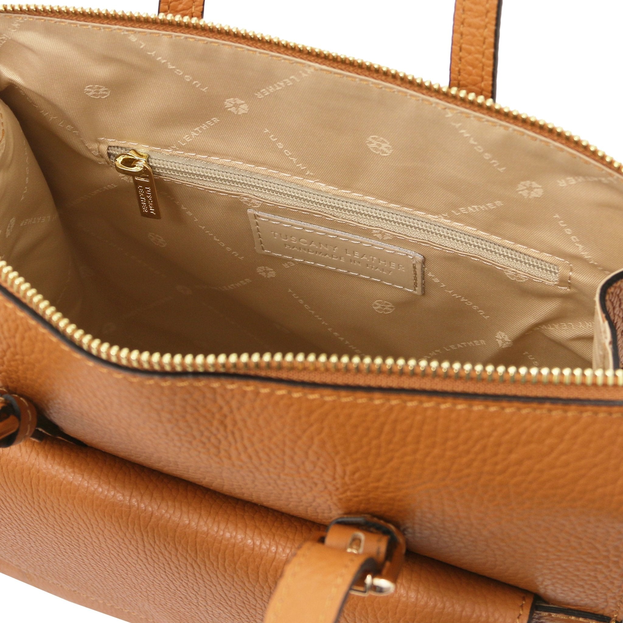 Interior zippered pocket view TL Bag Leather Backpack in cognac showing beige interior