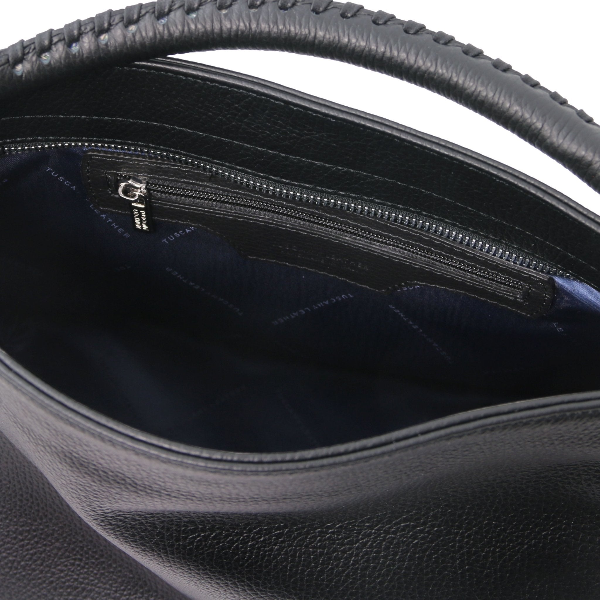 Interior view of the TL Bag Soft Leather Handbag in Black showing a zippered pocket and navy lining on a white background.