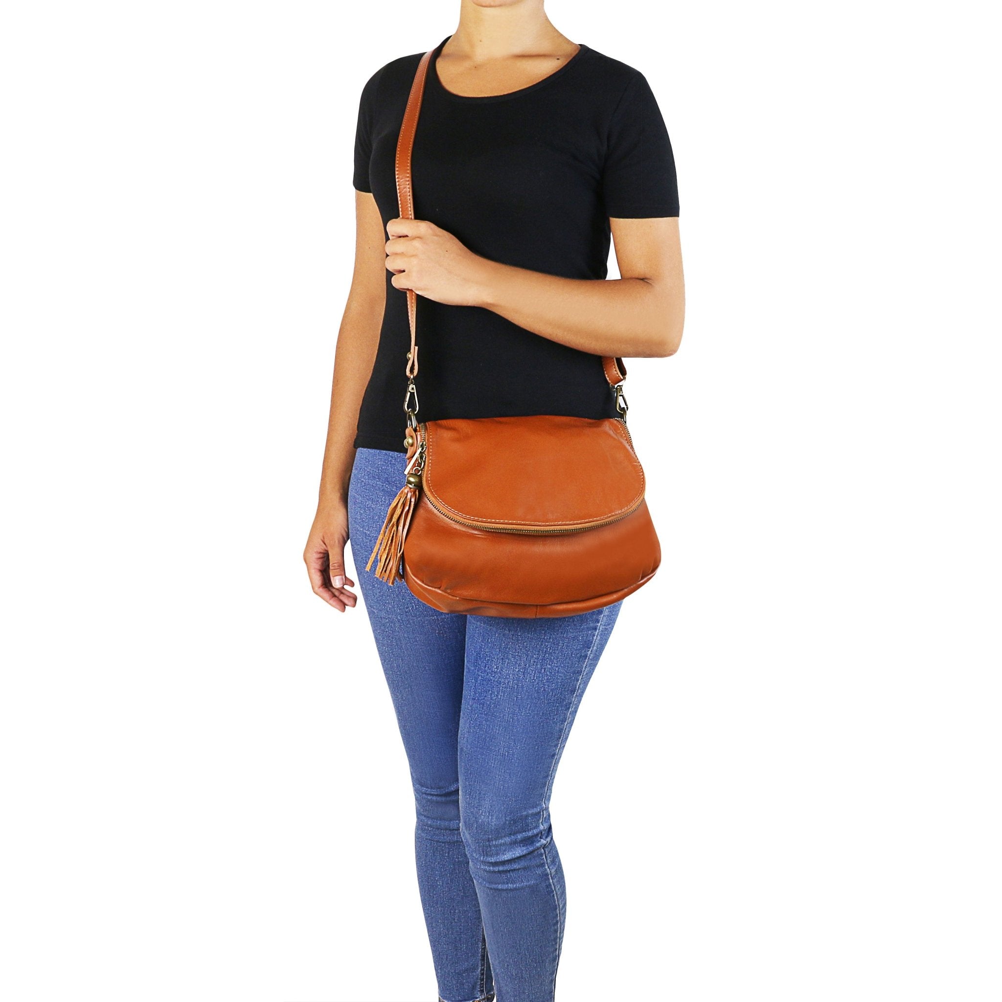 Model is wearing the TL Bag Soft Leather Shoulder Bag with Tassel Detail - Small Size in cognac crossbody