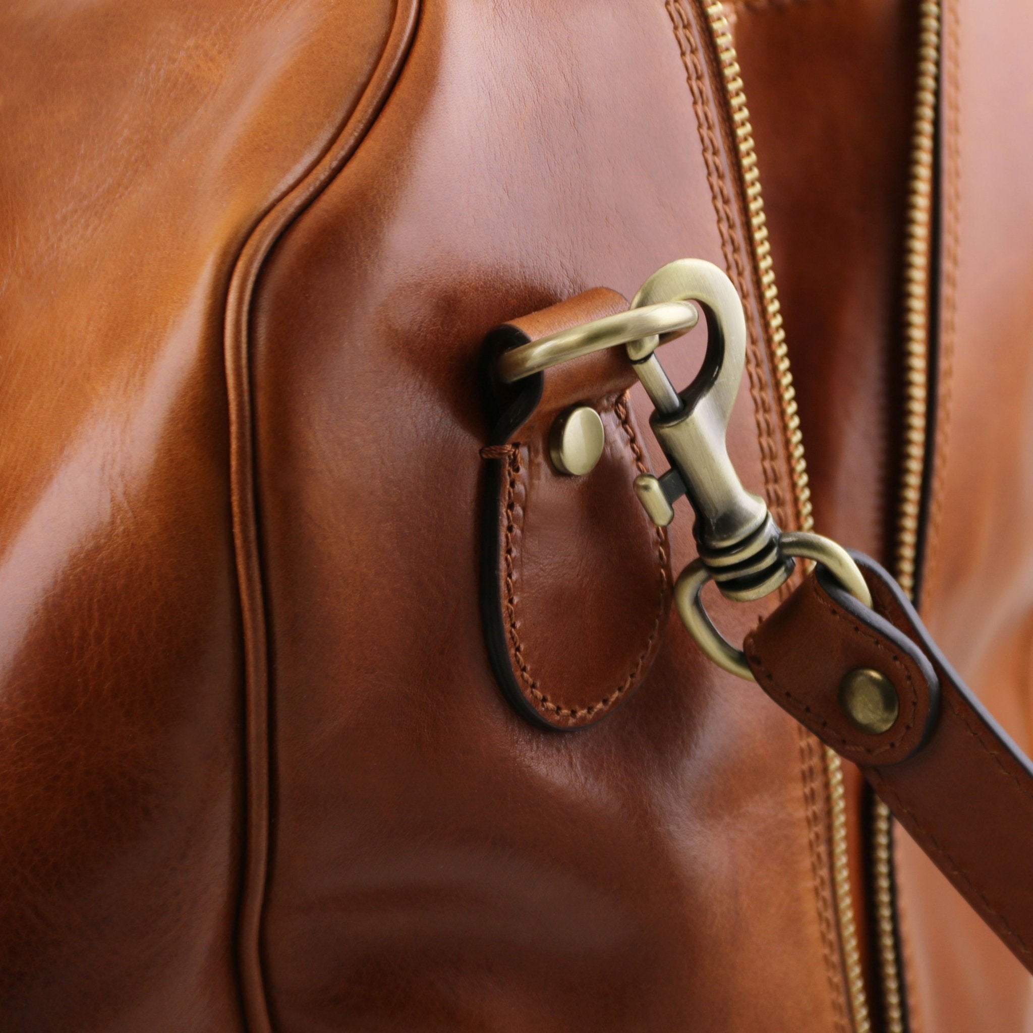Exterior shoulder strap clasp view TL Voyager Leather Travel Bag with Front Pocket in Honey