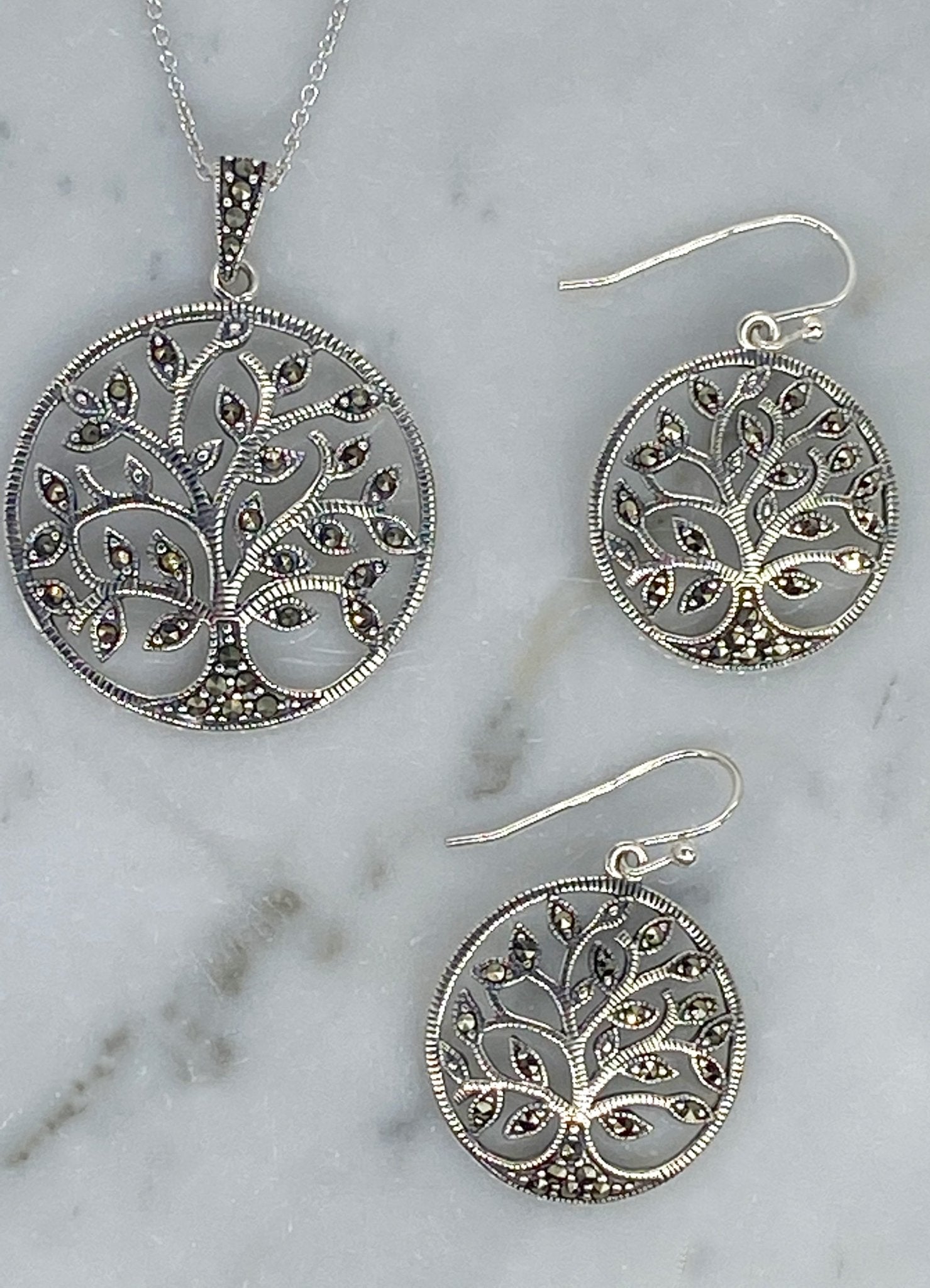 Tree of Life Sterling Silver Necklace and Earrings displayed on a piece of marble - L'Atelier Global