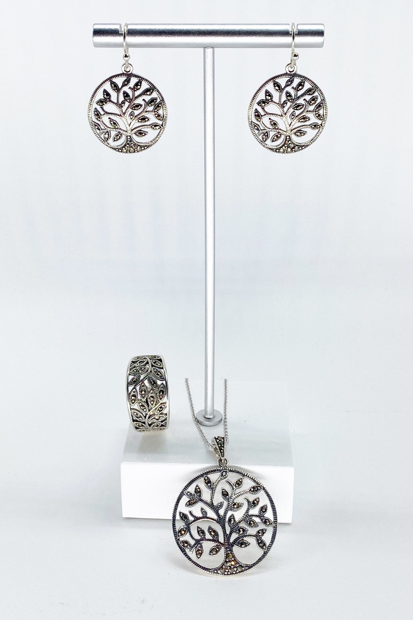 Tree of Life Sterling Silver Necklace, Earrings, and Ring displayed on a silver jewelry stand - L'Atelier Global
