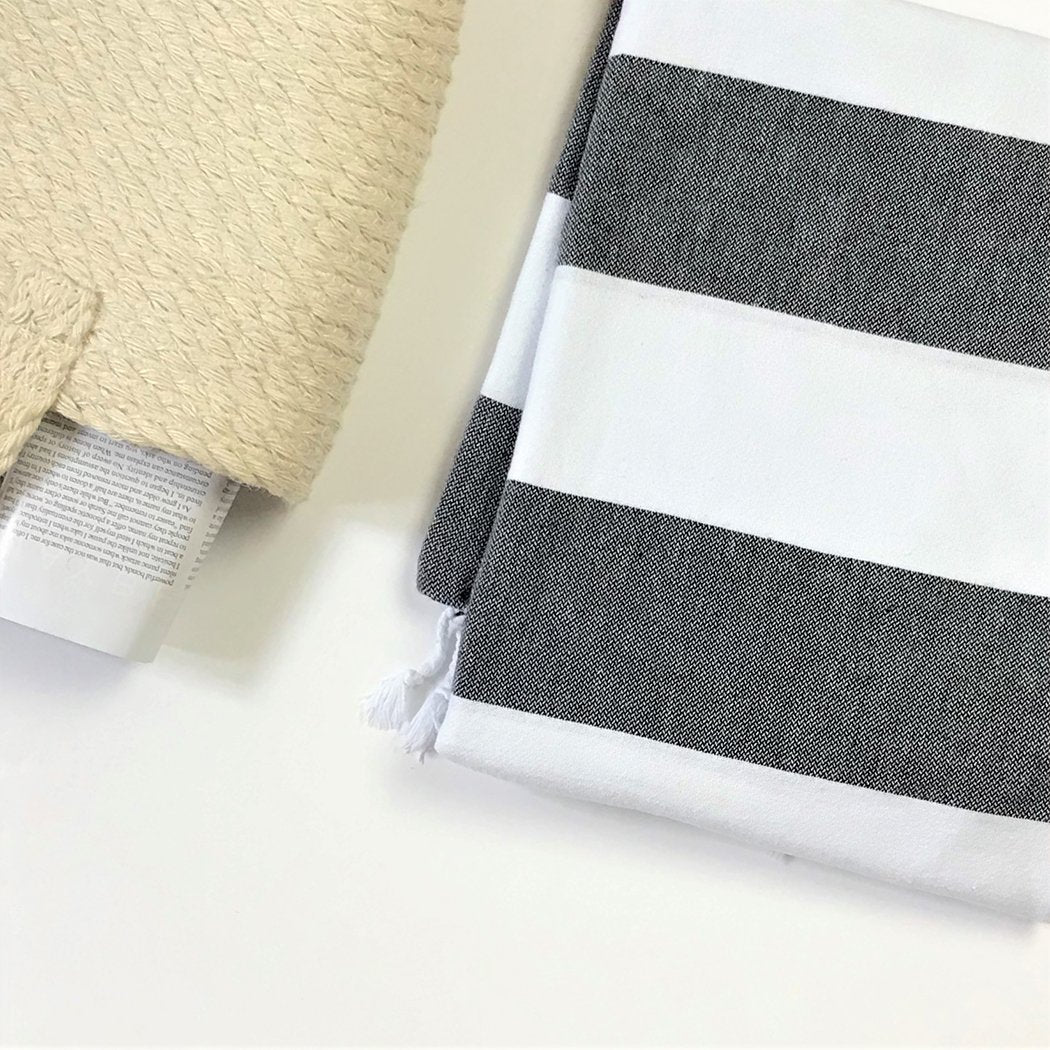 Turkish Aegean Cotton Cabana Towel in black and white stripes laying on the beach