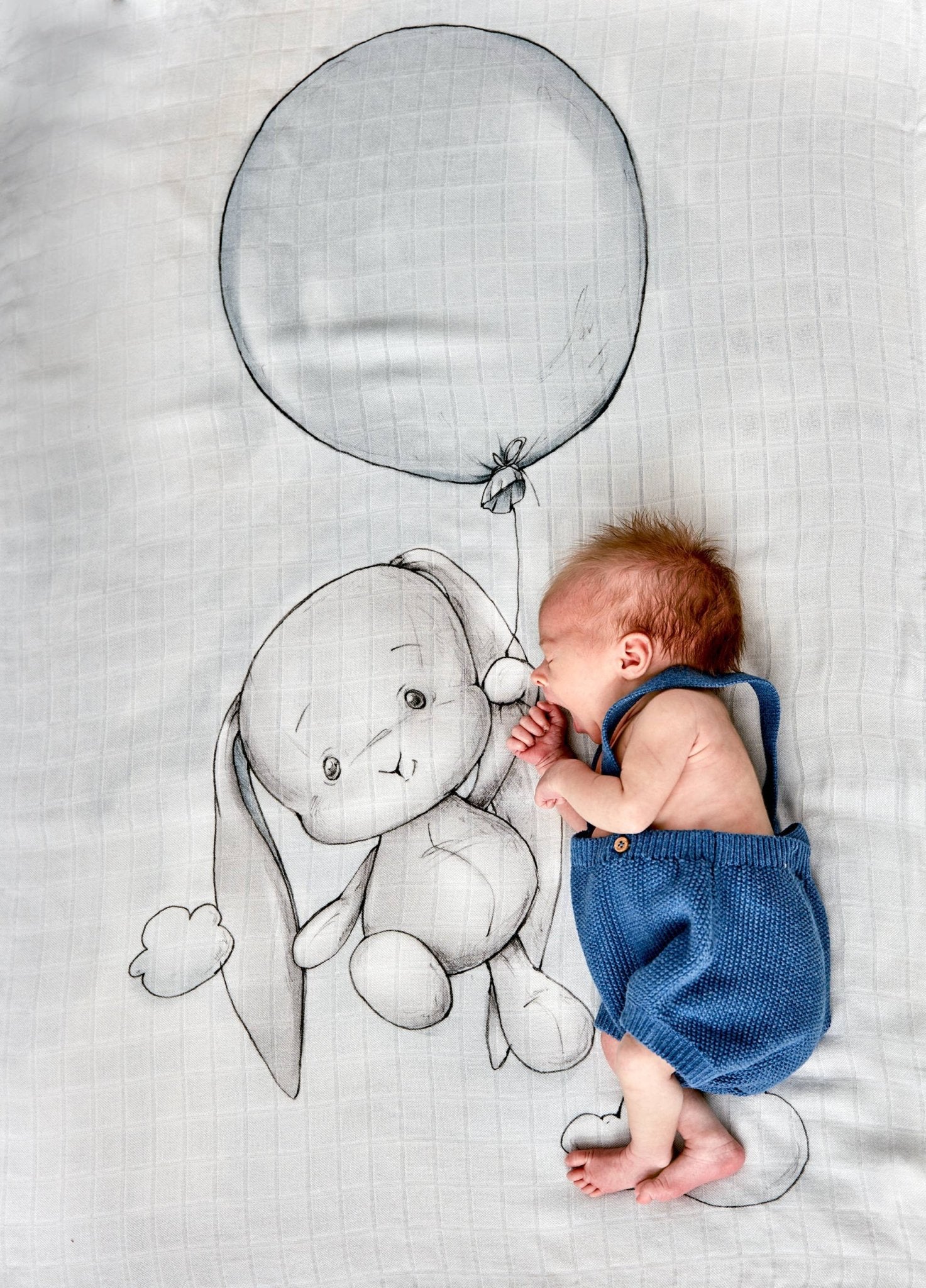 A baby laying on top of the Up Up and Away Bamboo Swaddle - L'Atelier Global