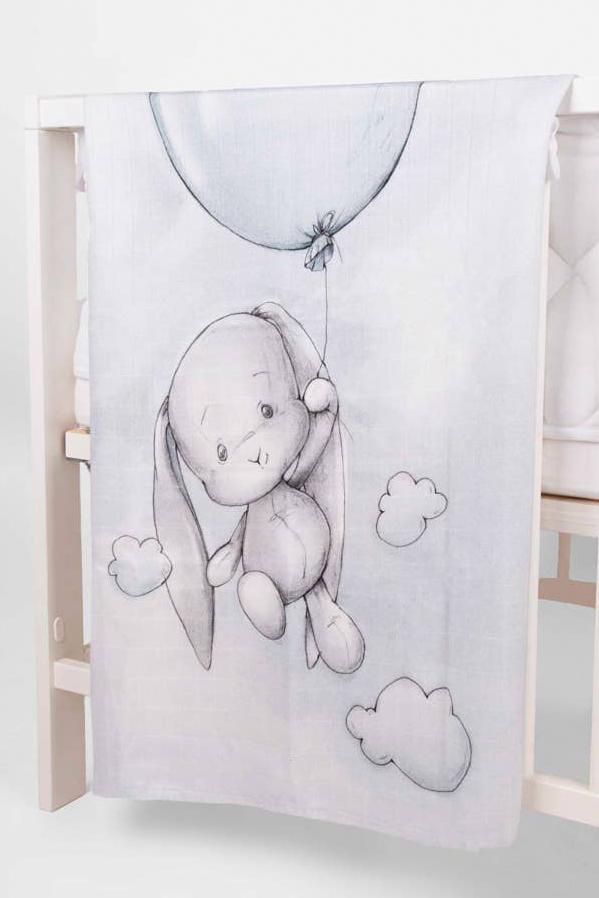 Up Up and Away Bamboo Swaddle laying over the side of a crib - L'Atelier Global
