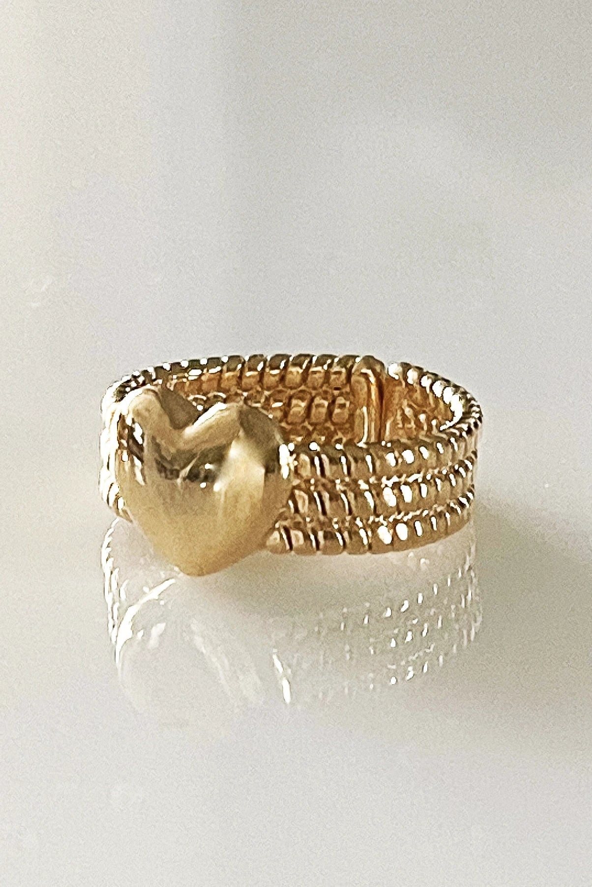 Verona Gratitude Heart Adjustable Ring on a glass table