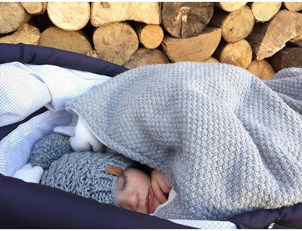 Wool & Fleece Double Blanket styled in outside covering a young baby in a crib - L'Atelier Global