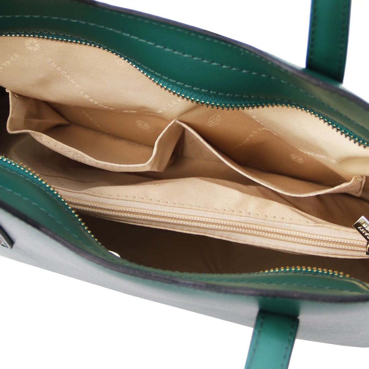Interior view of a teal handbag with visible stitching, two opened pockets, central zippered compartment and beige lining. 
