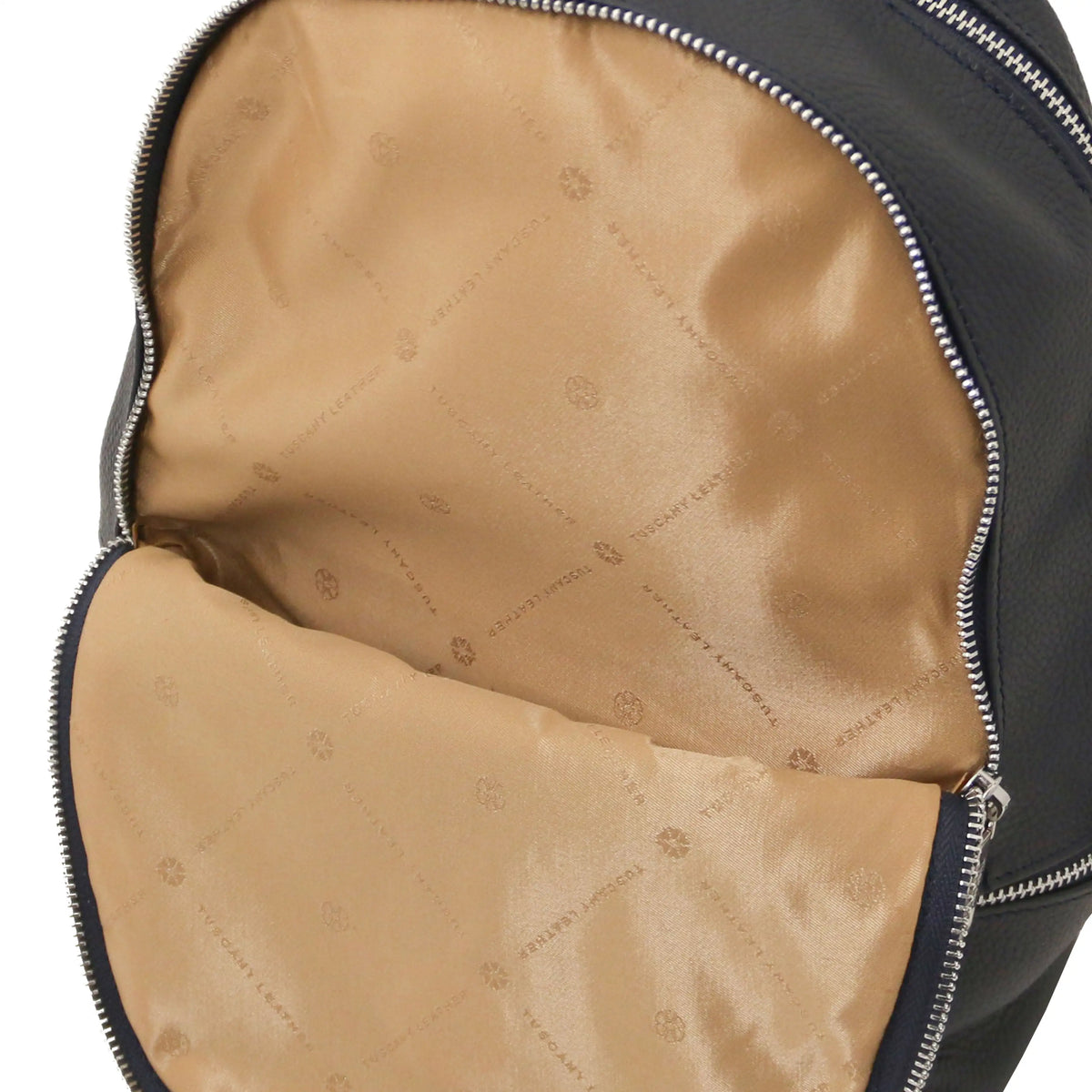 Close-up of a dark blue leather backpack showing the beige  interior lining and silver zipper.