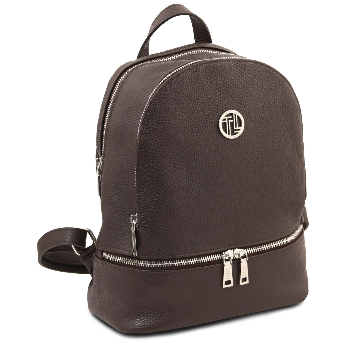 A dark brown pebbled leather backpack with silver-tone hardware, featuring a top handle, a lower zippered compartment, and a circular metallic logo emblem on the front.
