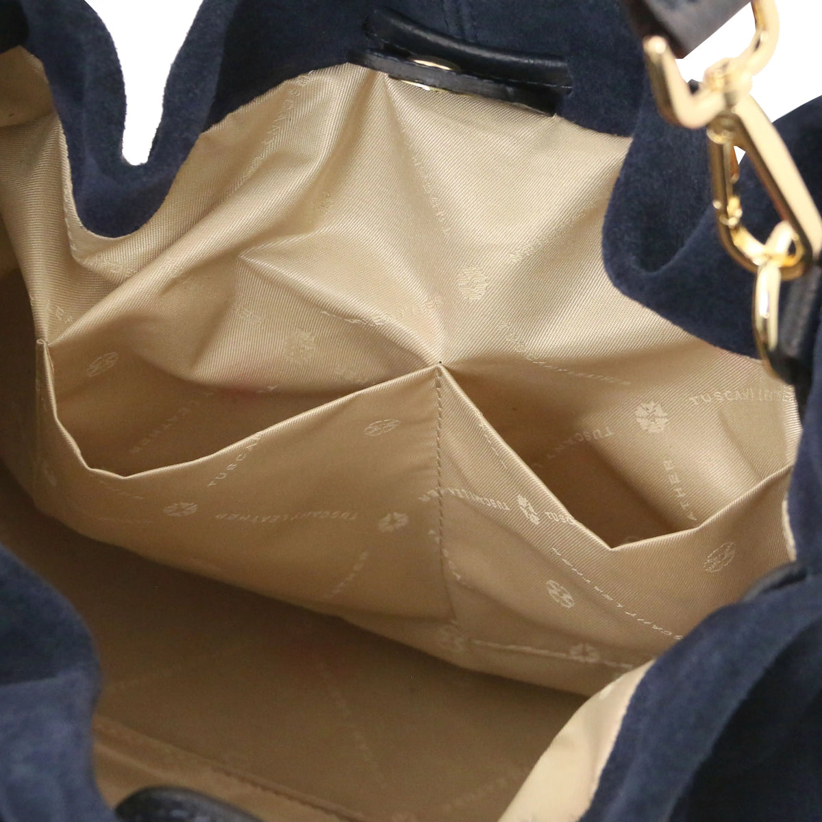 Close-up of the interior of a dark blue  shopper bag, showing a beige satin-like lining with a diamond pattern and gold-tone hardware.