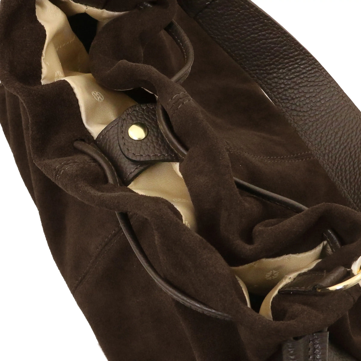 Close-up of a dark brown suede shoulder bag with a pebbled leather strap and a cream-colored interior lining.