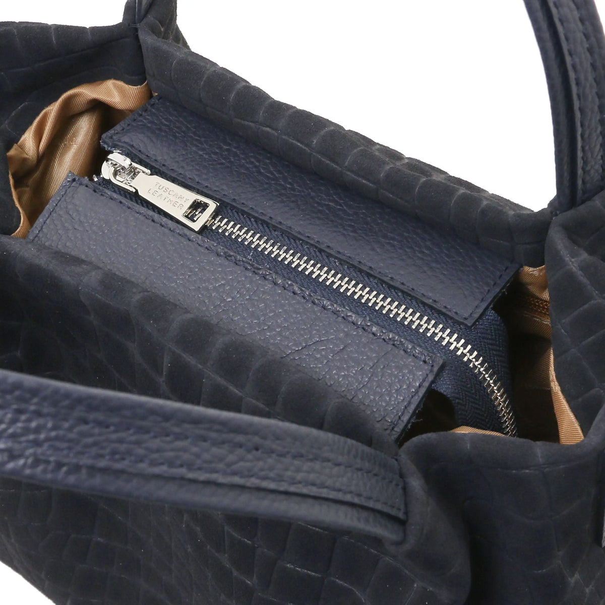 Close-up of a dark blue textured handbag interior showing a zippered compartment, silver zipper pulls, and a red lining.