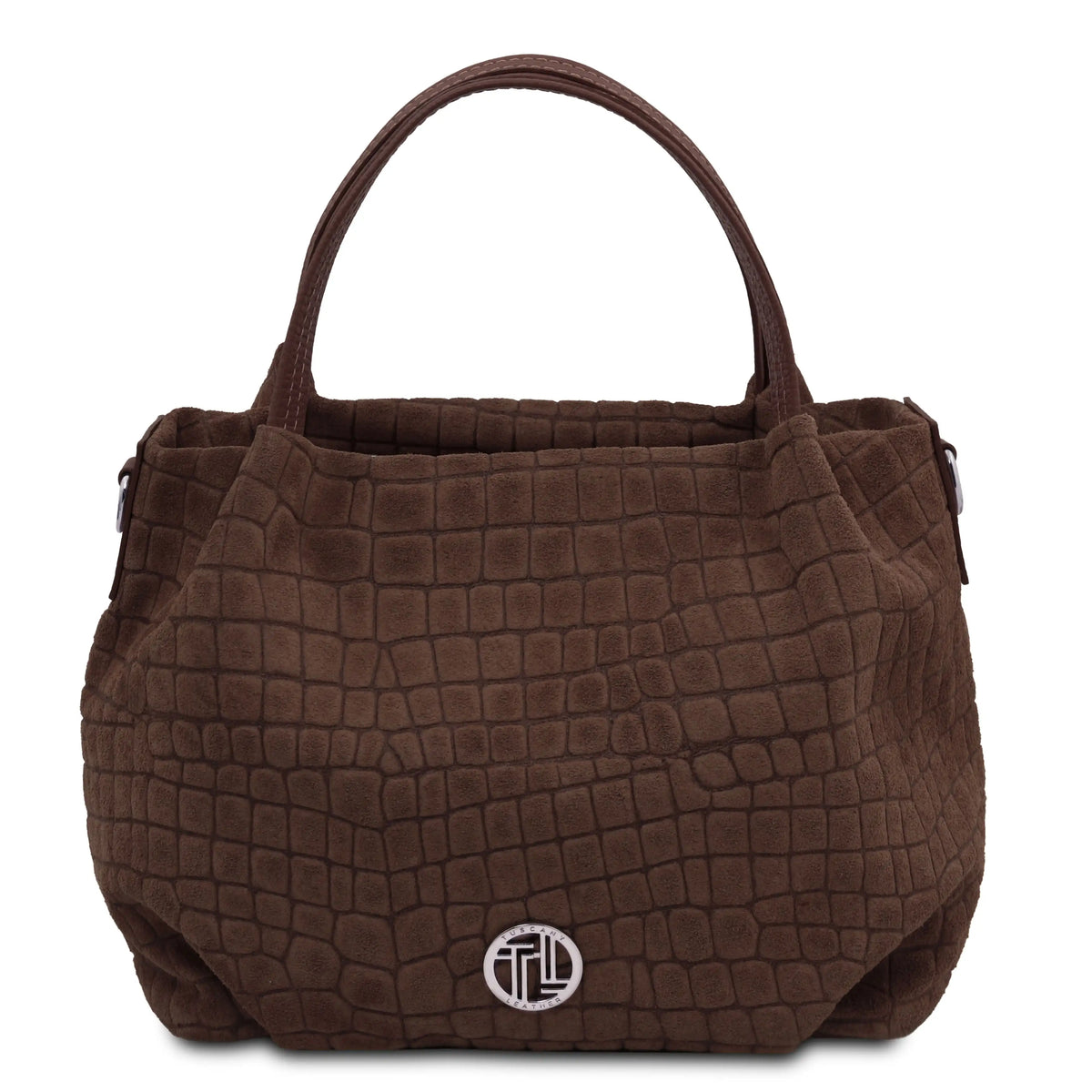 A chocolate textured handbag with a crocodile-embossed pattern, featuring dual top handles and a silver-toned circular logo medallion on the front, set against a plain white background.