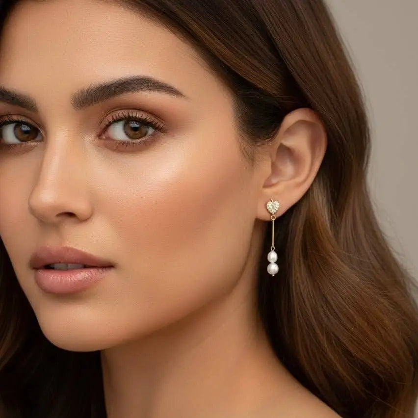 A woman is wearing the Amalfi Monstera Leaf Drop Earrings on a neutral background