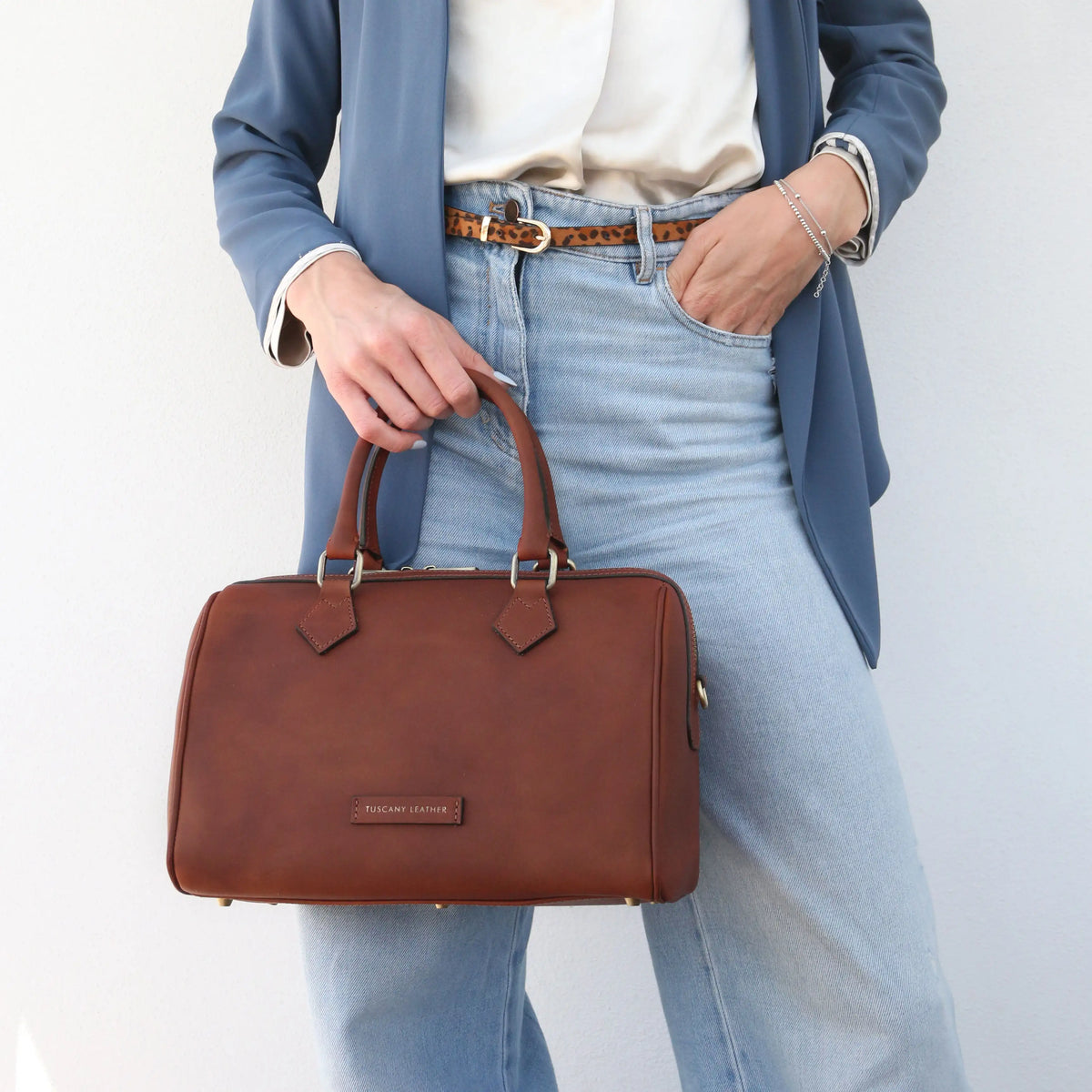 Person holding Barrique Italian Leather Mini Duffle Handbag in brown on a plain background