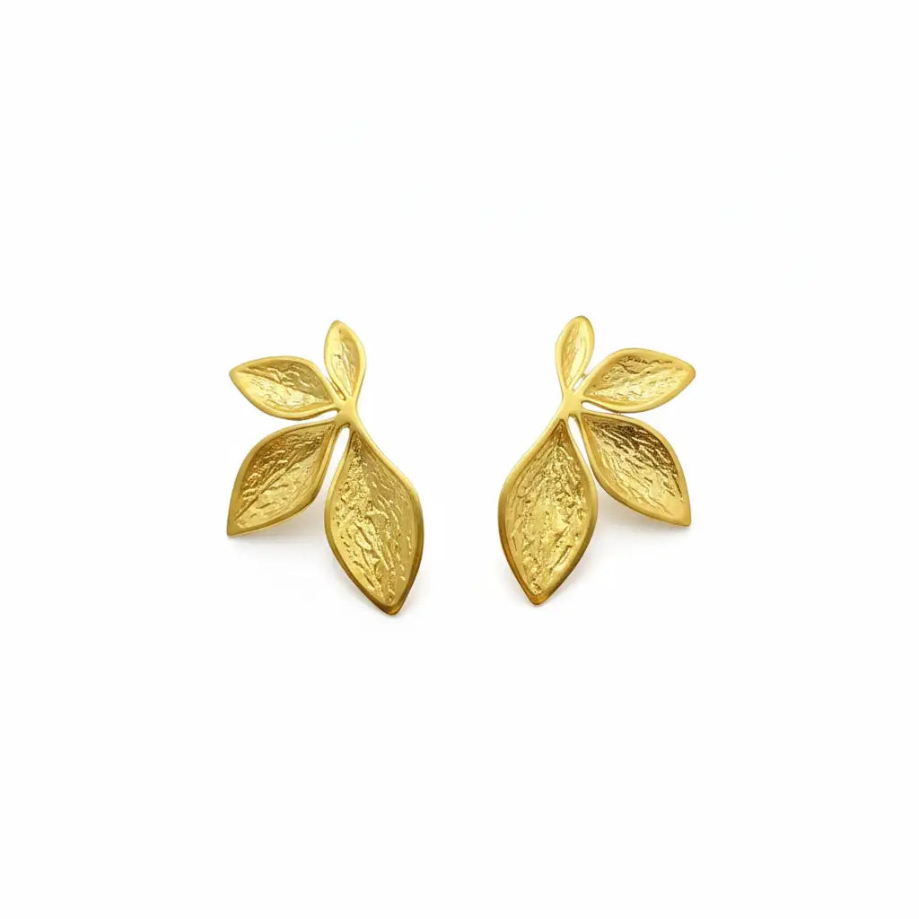 Two gold leaf-shaped stud earrings displayed on a white background