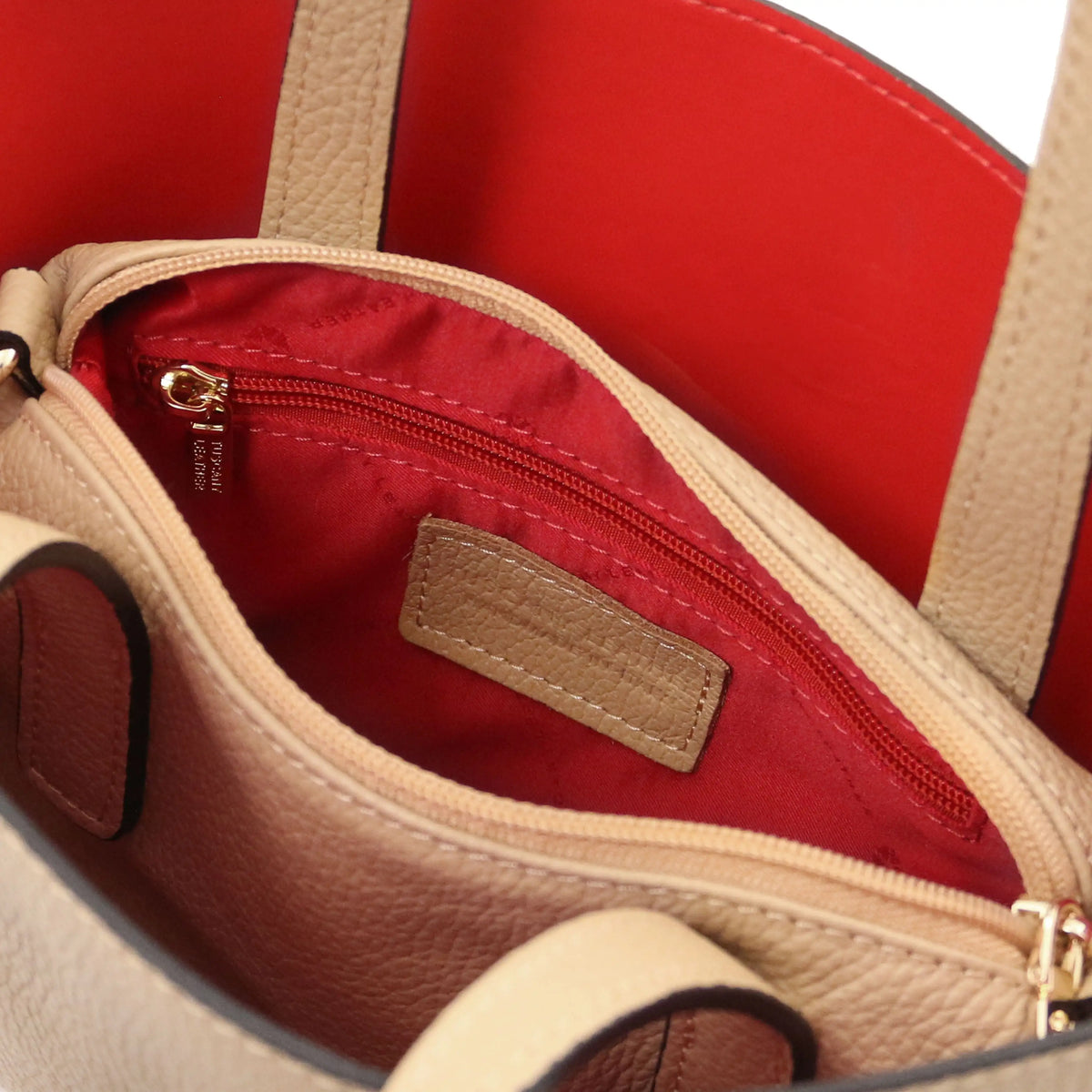 Interior red lining view Agatha Leather Handbag in caramel showing un zipped central compartment