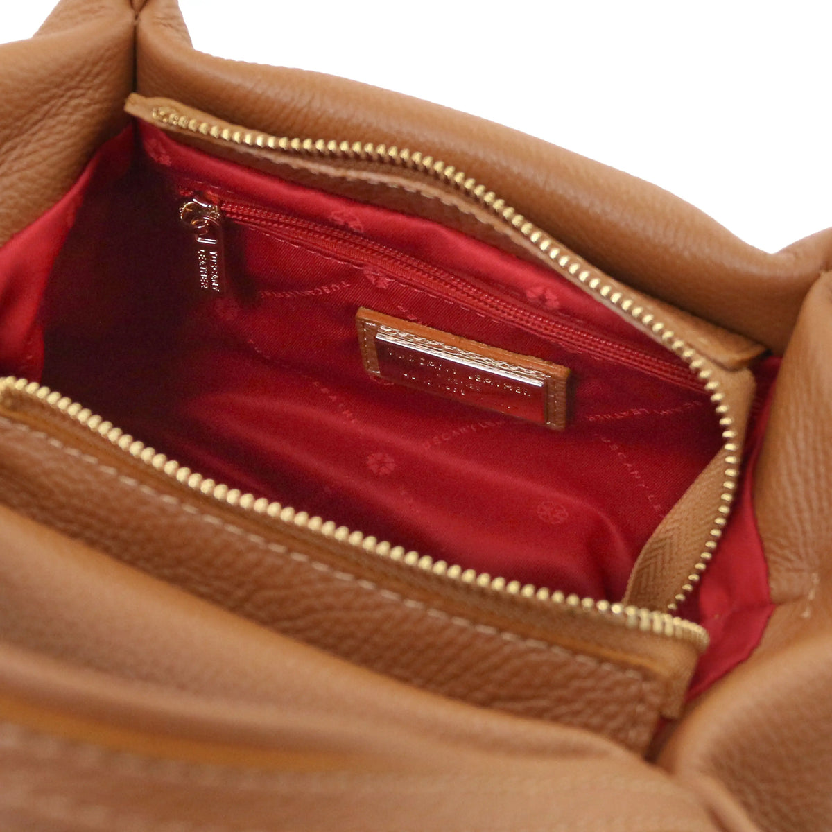 Interior zip pocket view Nora Soft Italian Leather Shoulder Bag in cognac with red lining