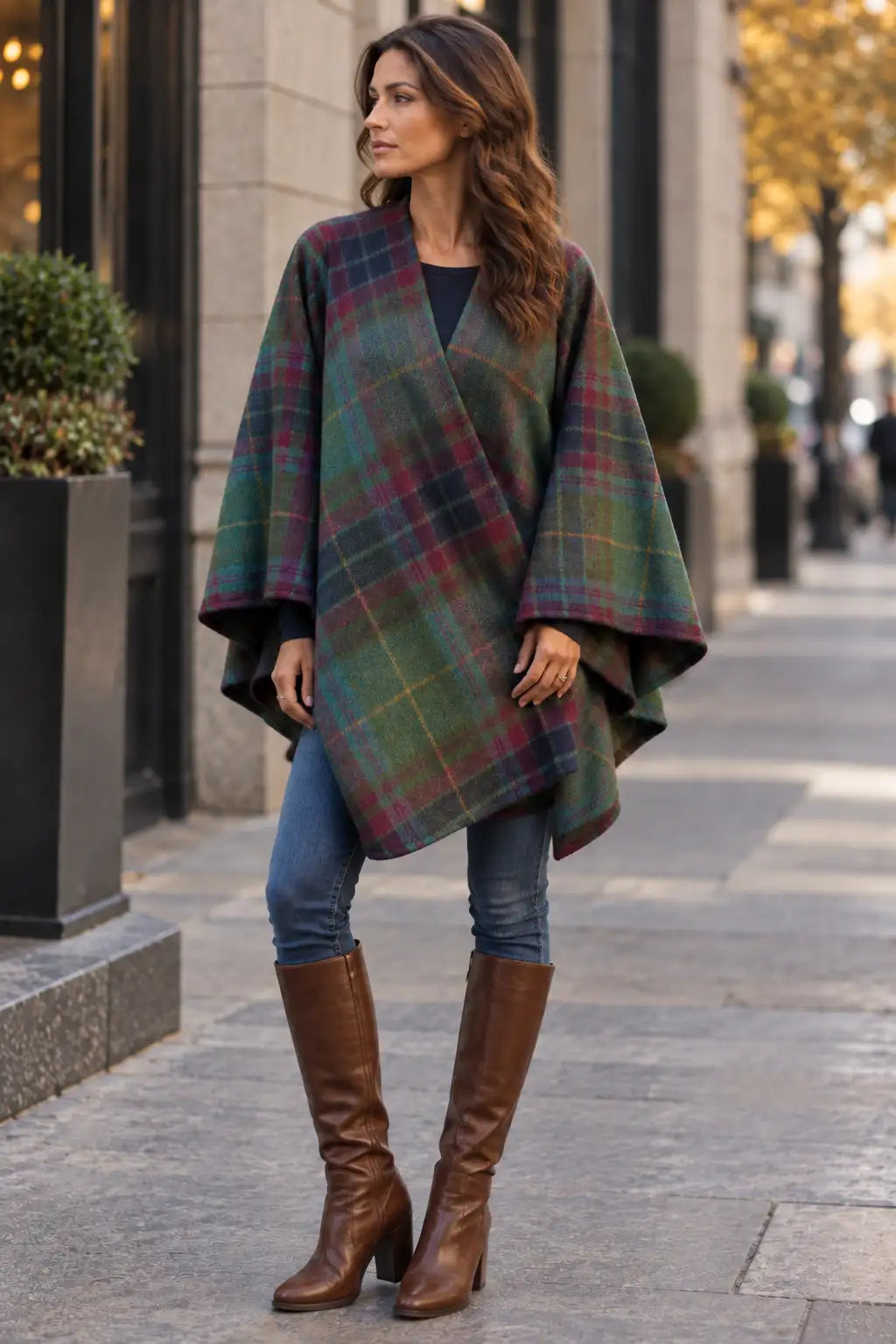 Woman wearing Irish Emerald Isle Tartan Ruana Wrap and brown boots in a city environment