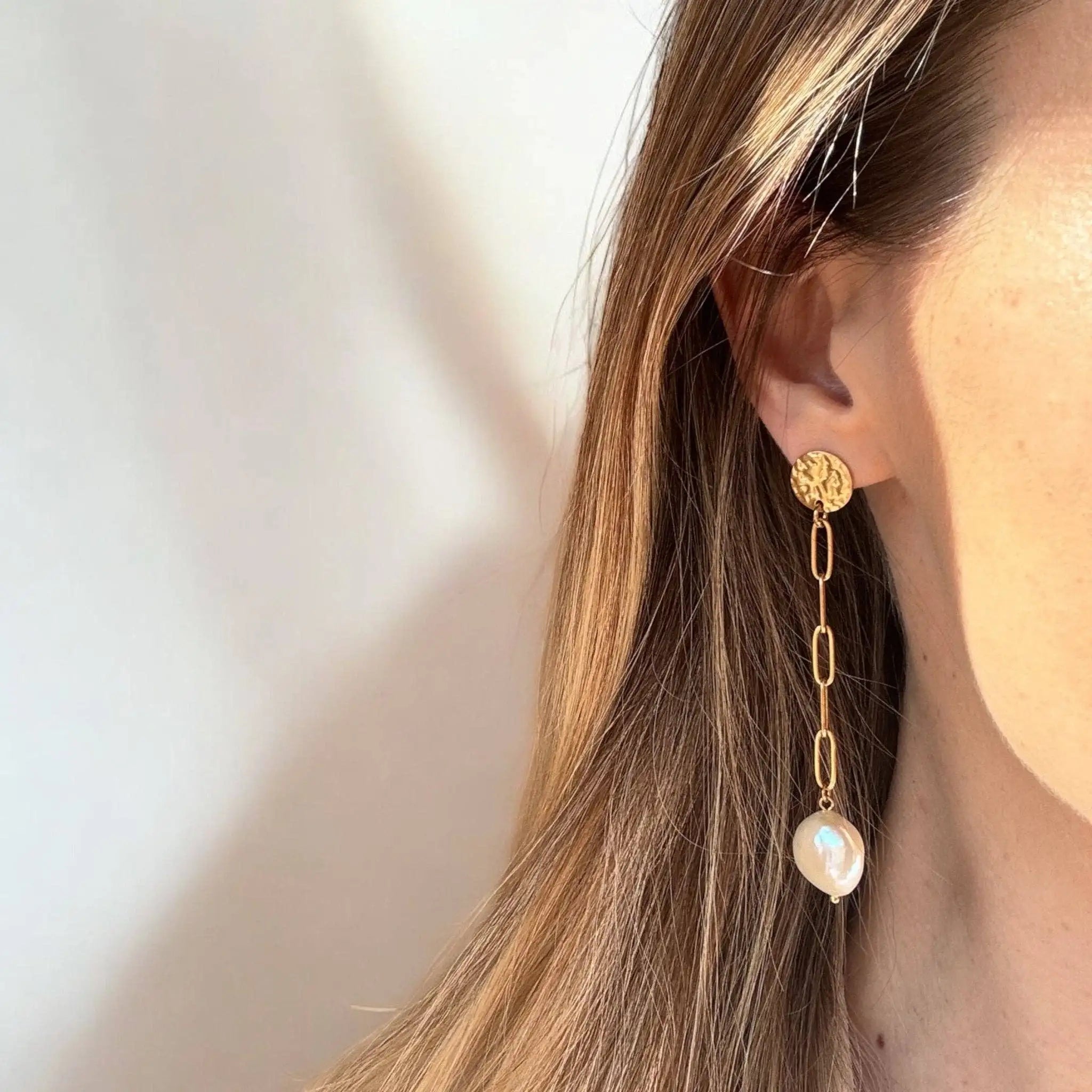 Close up of a woman's ear wearing the Isabel Drop Earrings 