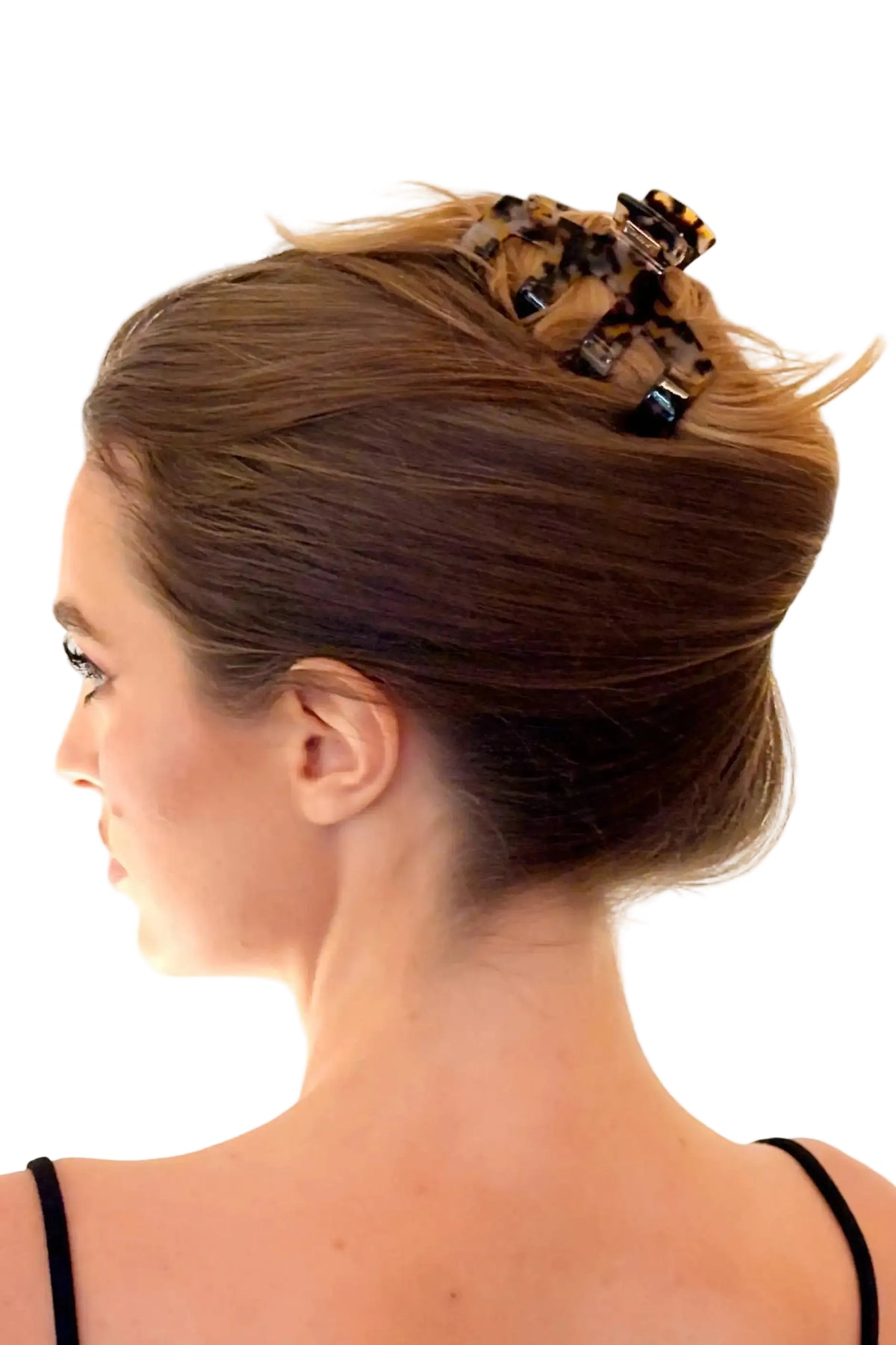 A woman shown from the side profile wearing a leopard-print hair claw clip to secure her hair in an updo, against a plain white background.